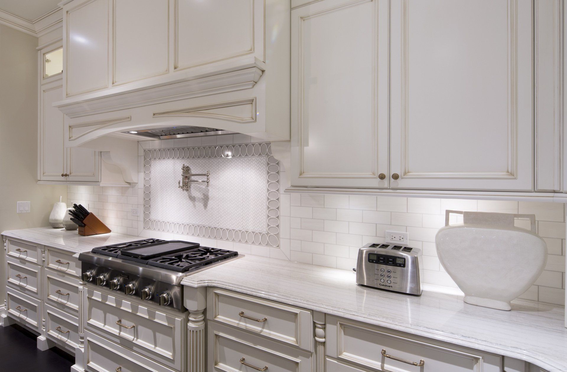 A kitchen with white cabinets and a stove top oven