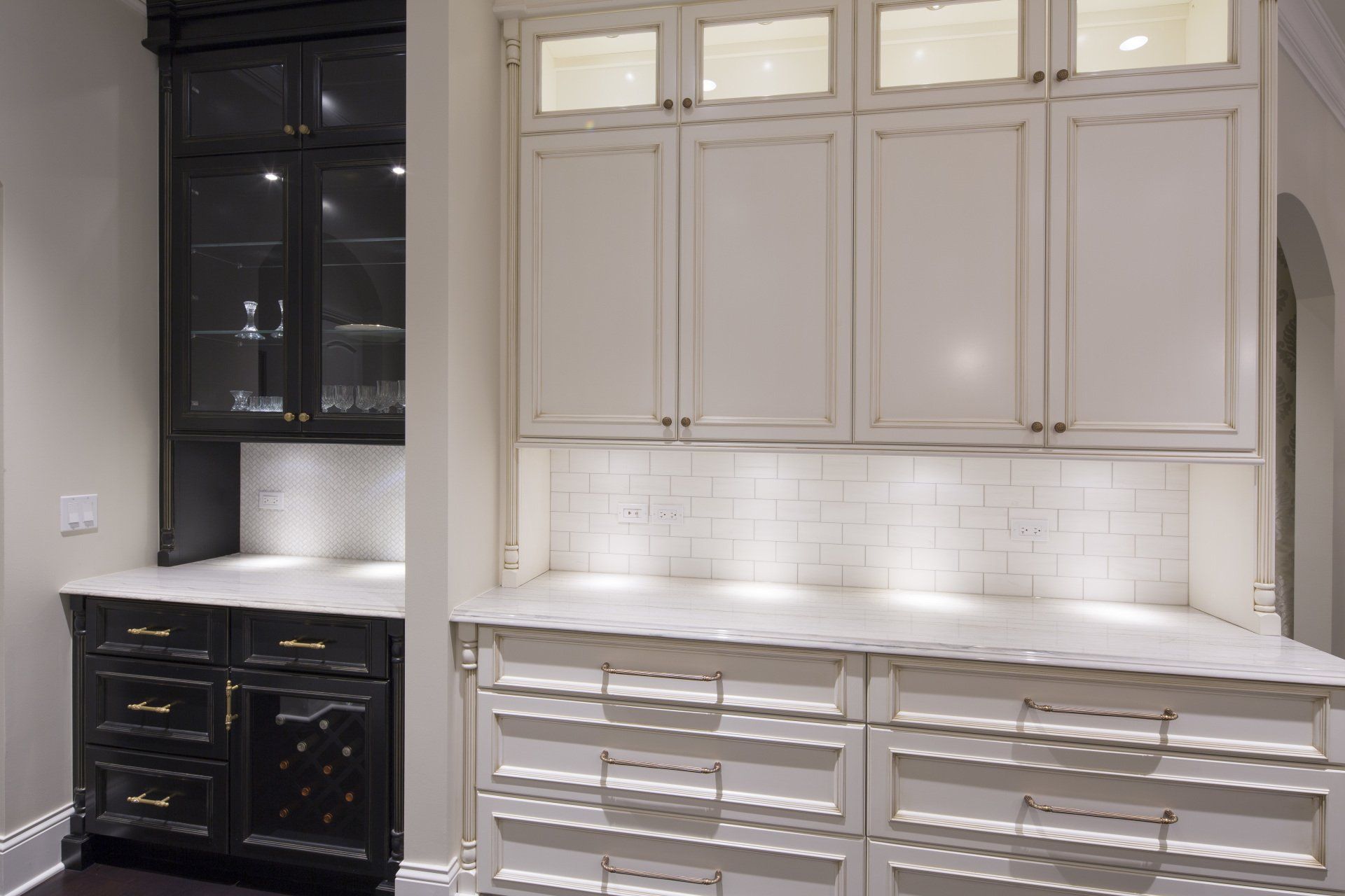 A kitchen with white cabinets and black cabinets