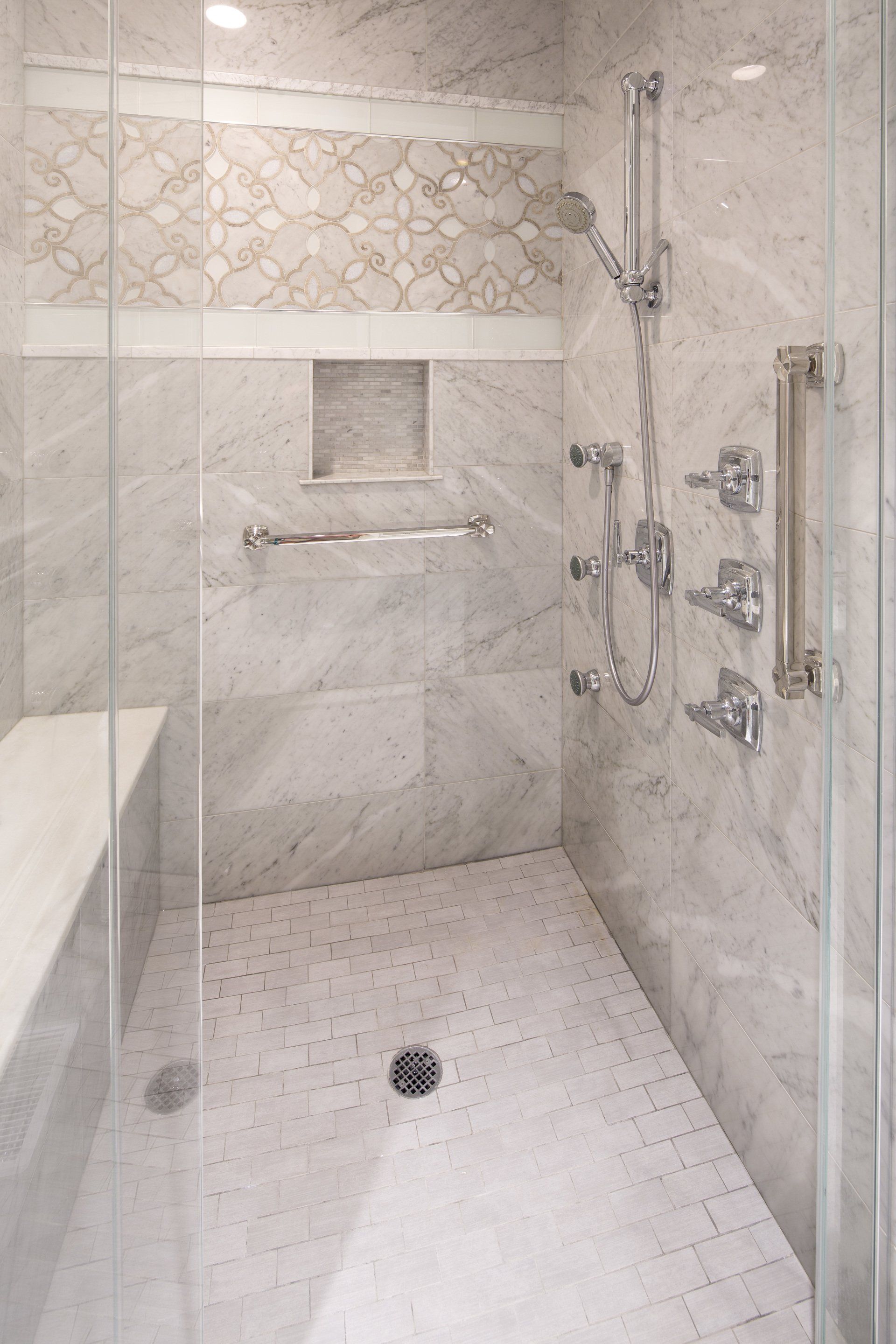 A bathroom with a walk in shower and a bench.
