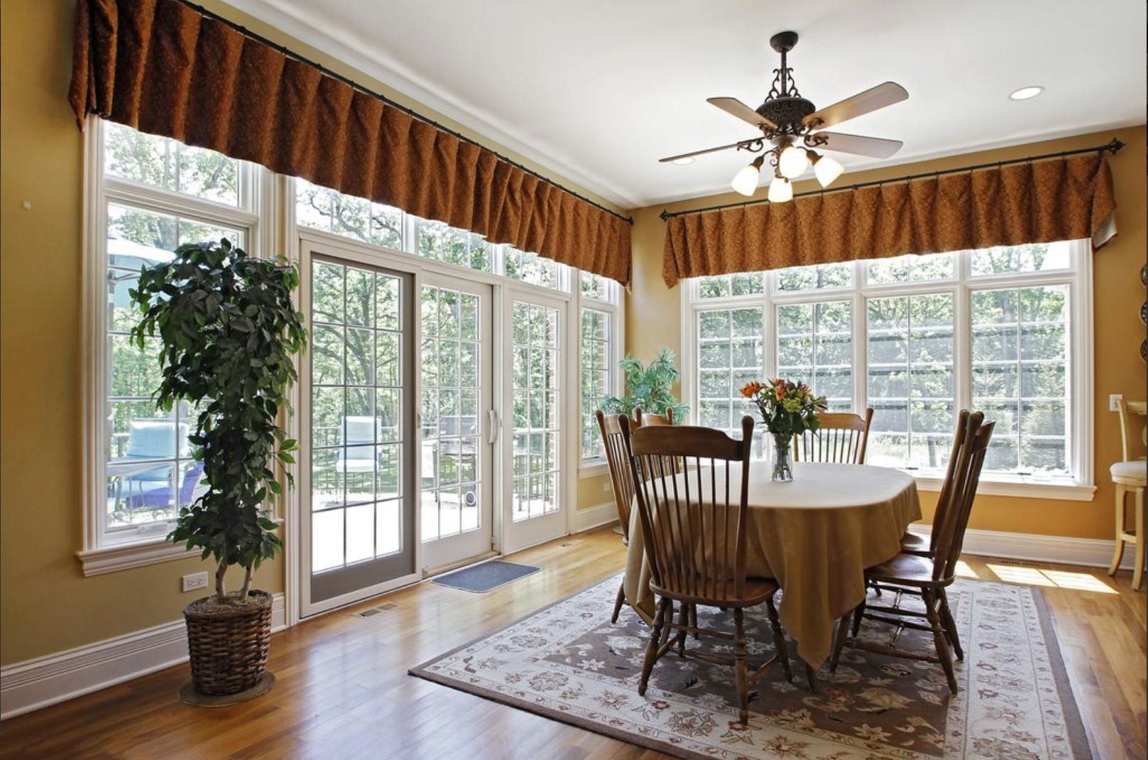 A dining room with a table and chairs and a ceiling fan