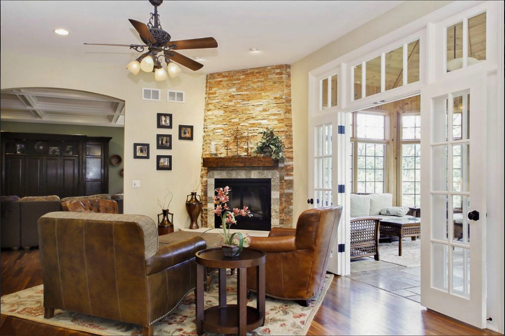 A living room with a fireplace and a ceiling fan