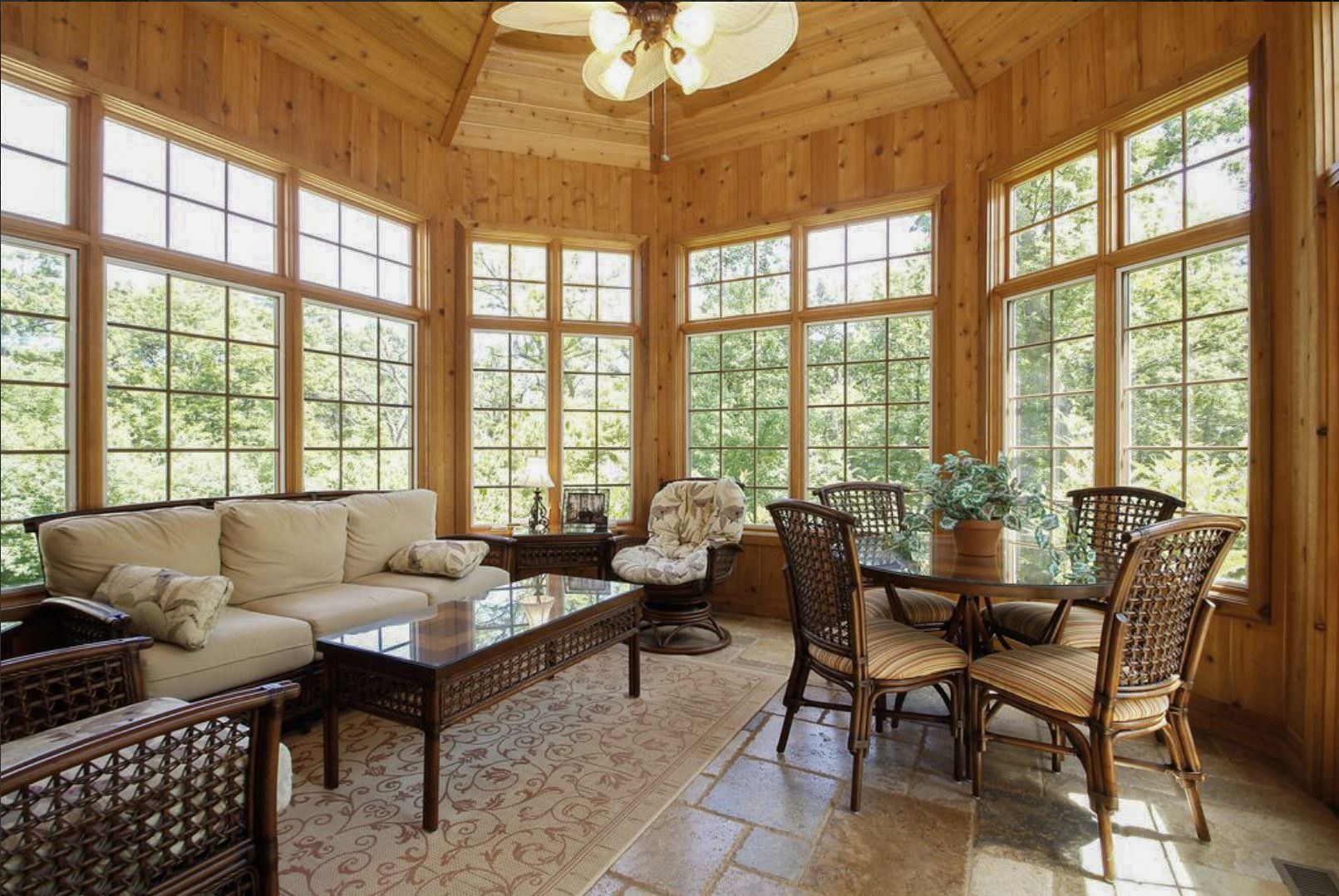 A living room with a couch , table , chairs and a ceiling fan.