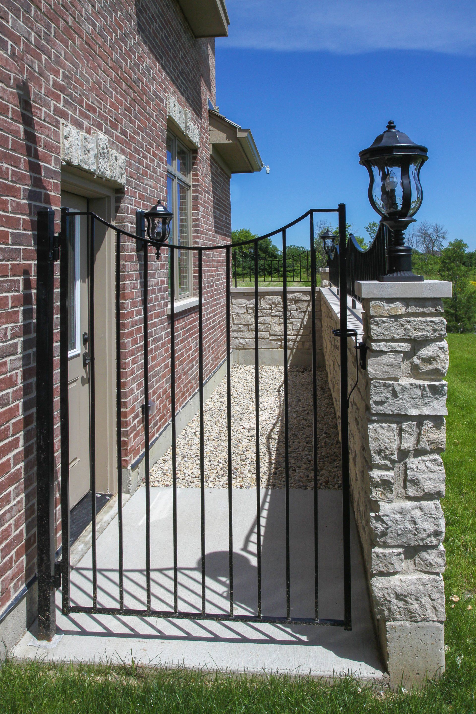 A wrought iron gate leading to a brick building