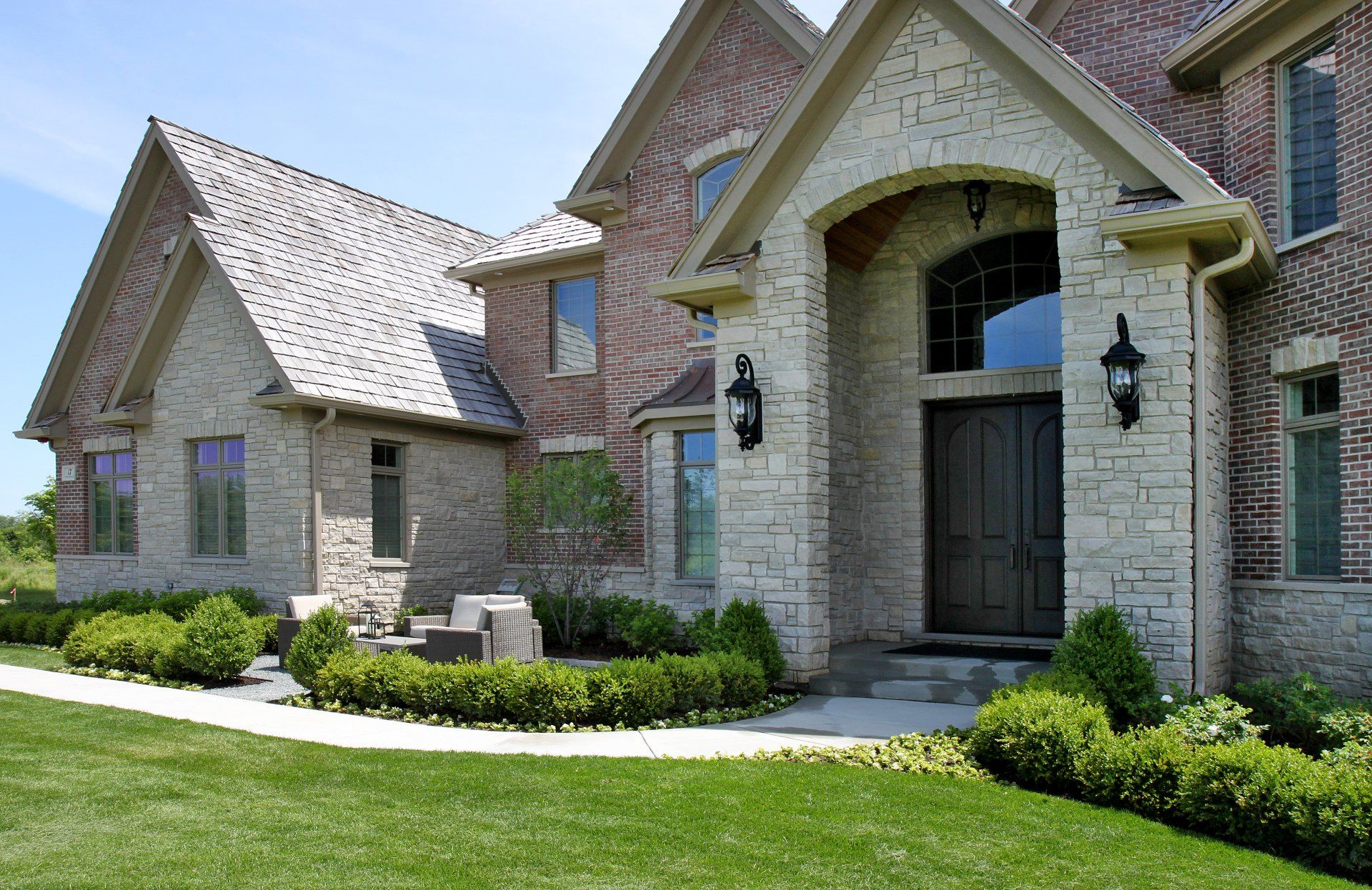 A large brick house with a lush green lawn in front of it