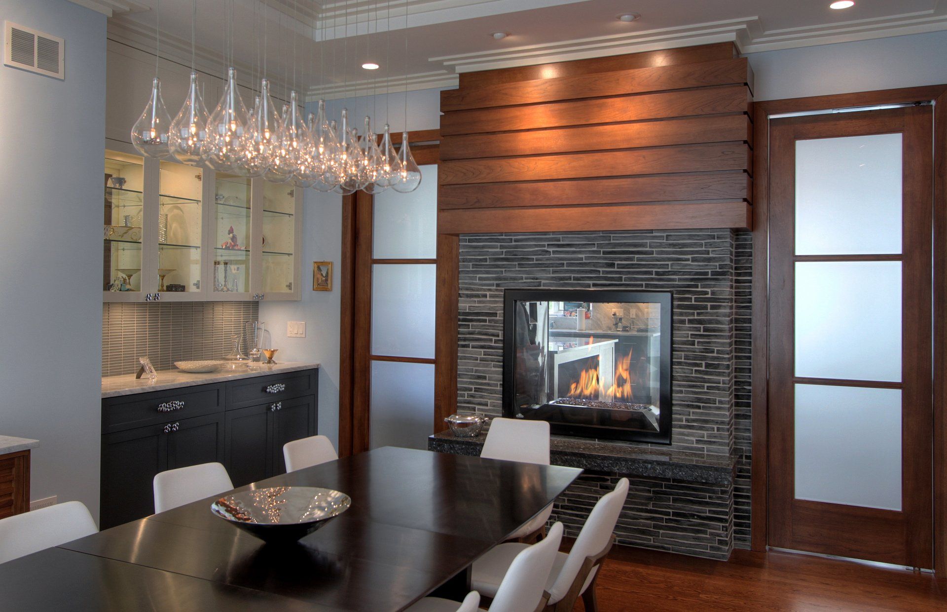 A dining room with a table and chairs and a fireplace