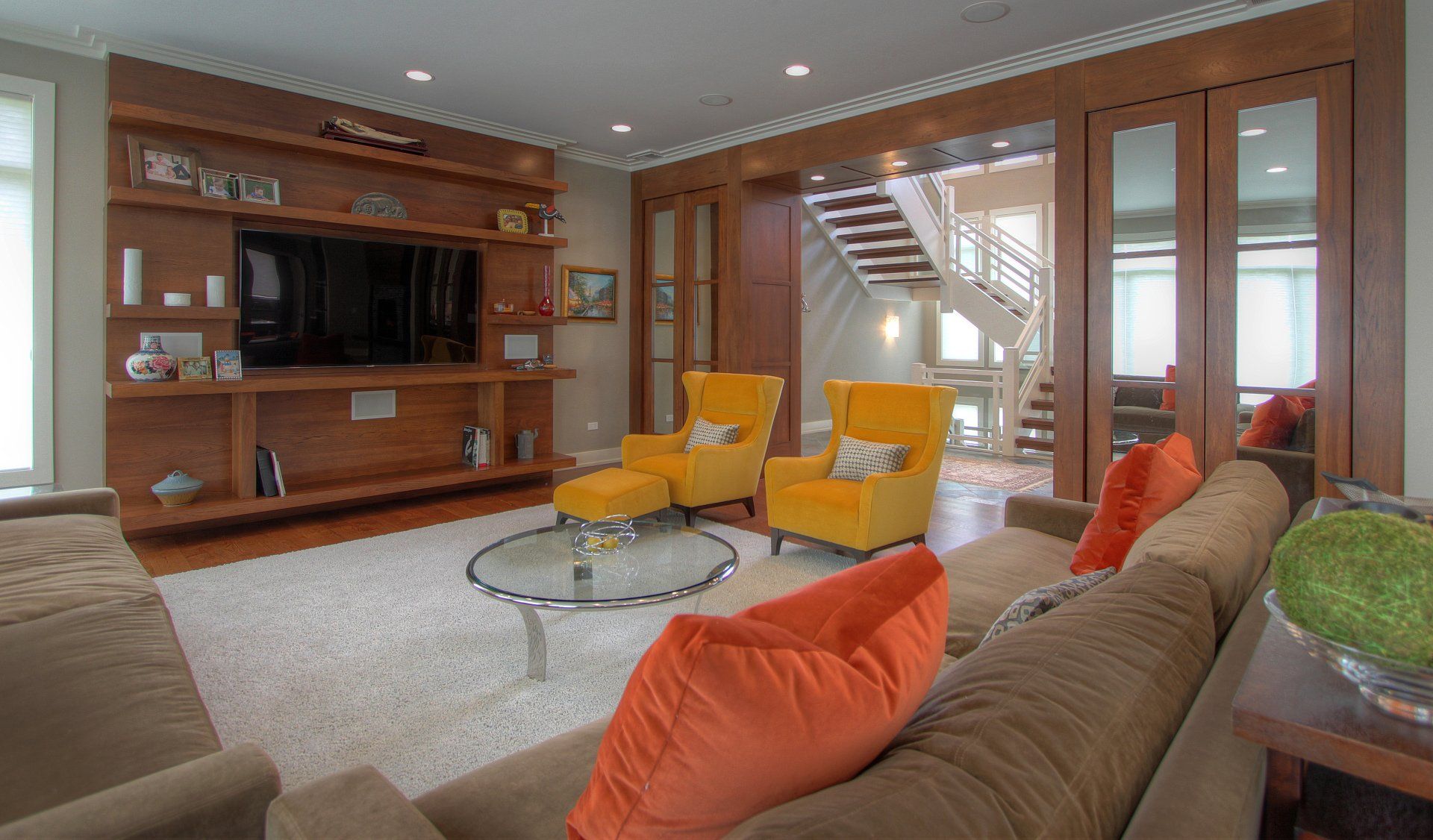 A living room with a couch , chairs , and a television.
