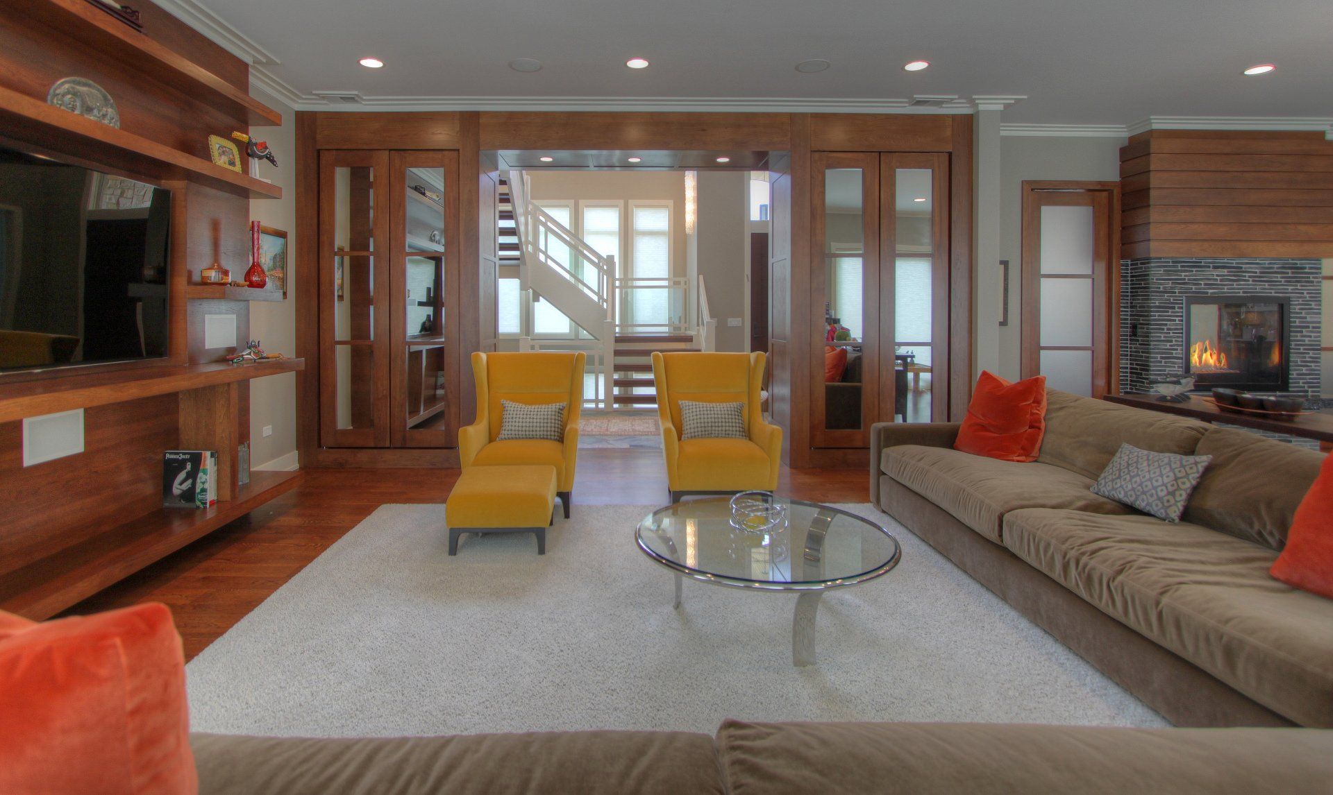 A living room with a couch , two chairs , a coffee table and a fireplace.