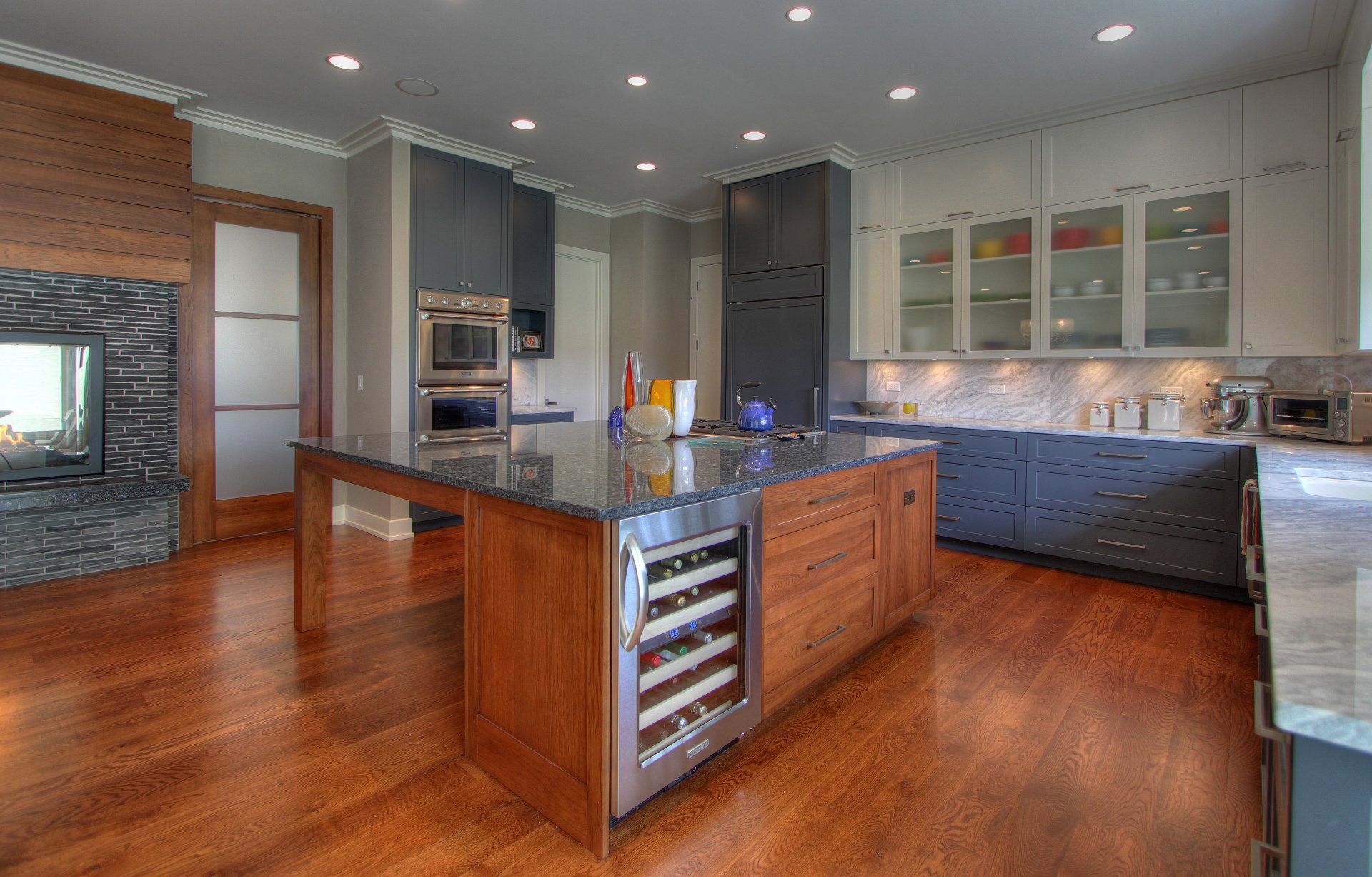 A kitchen with a large island and a wine cooler.