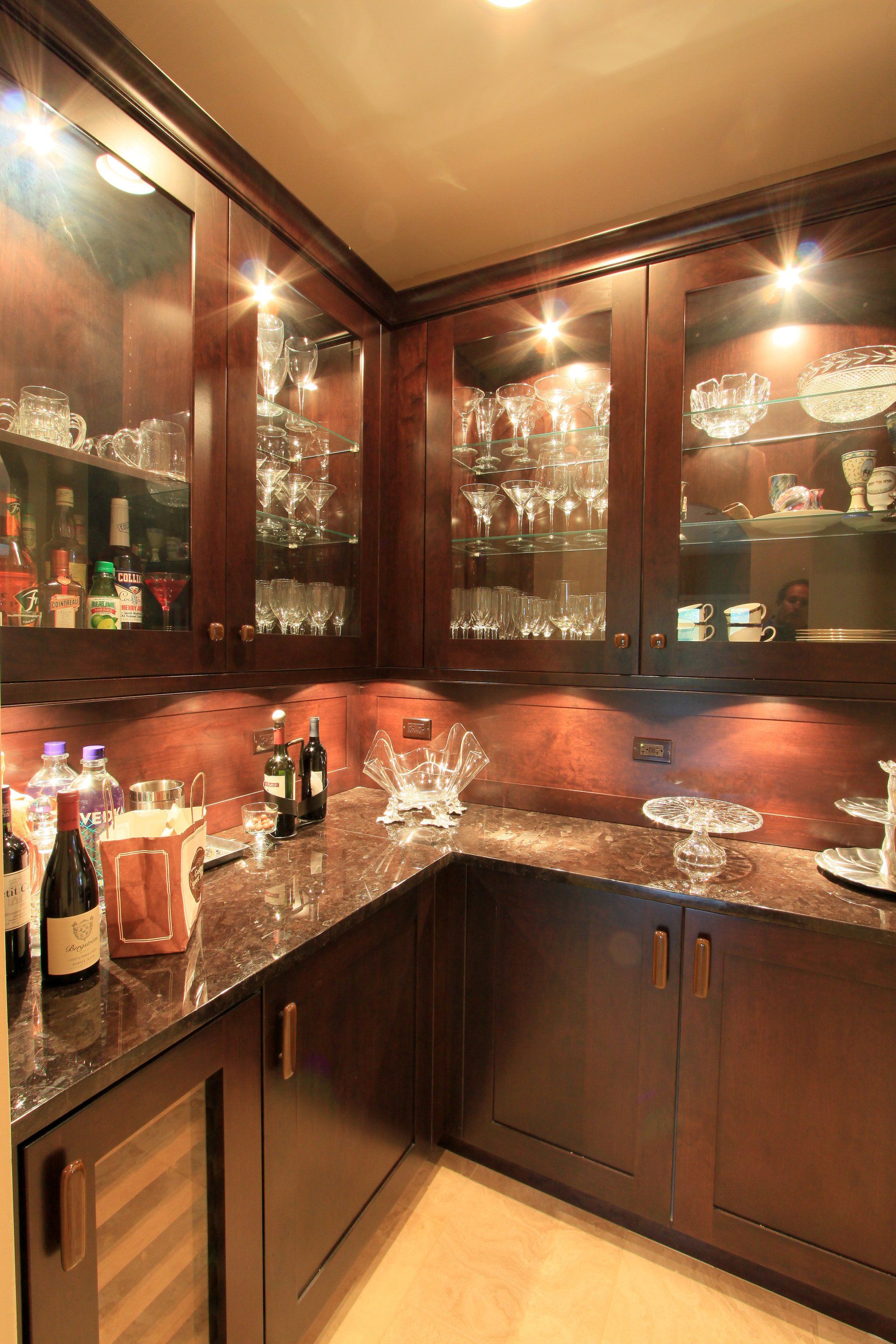 A kitchen with wine bottles and glasses on the counter