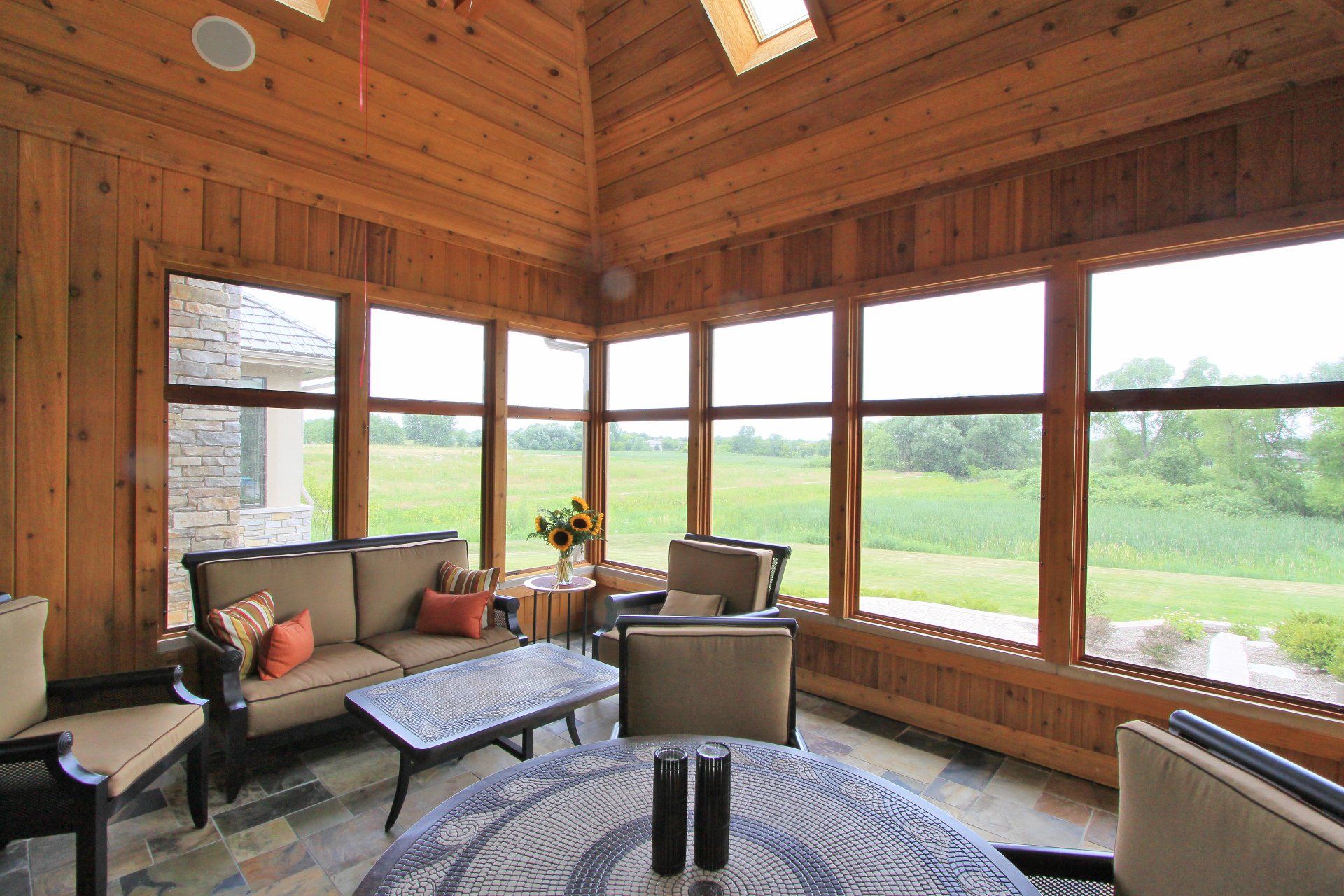 A living room with a lot of windows and a table