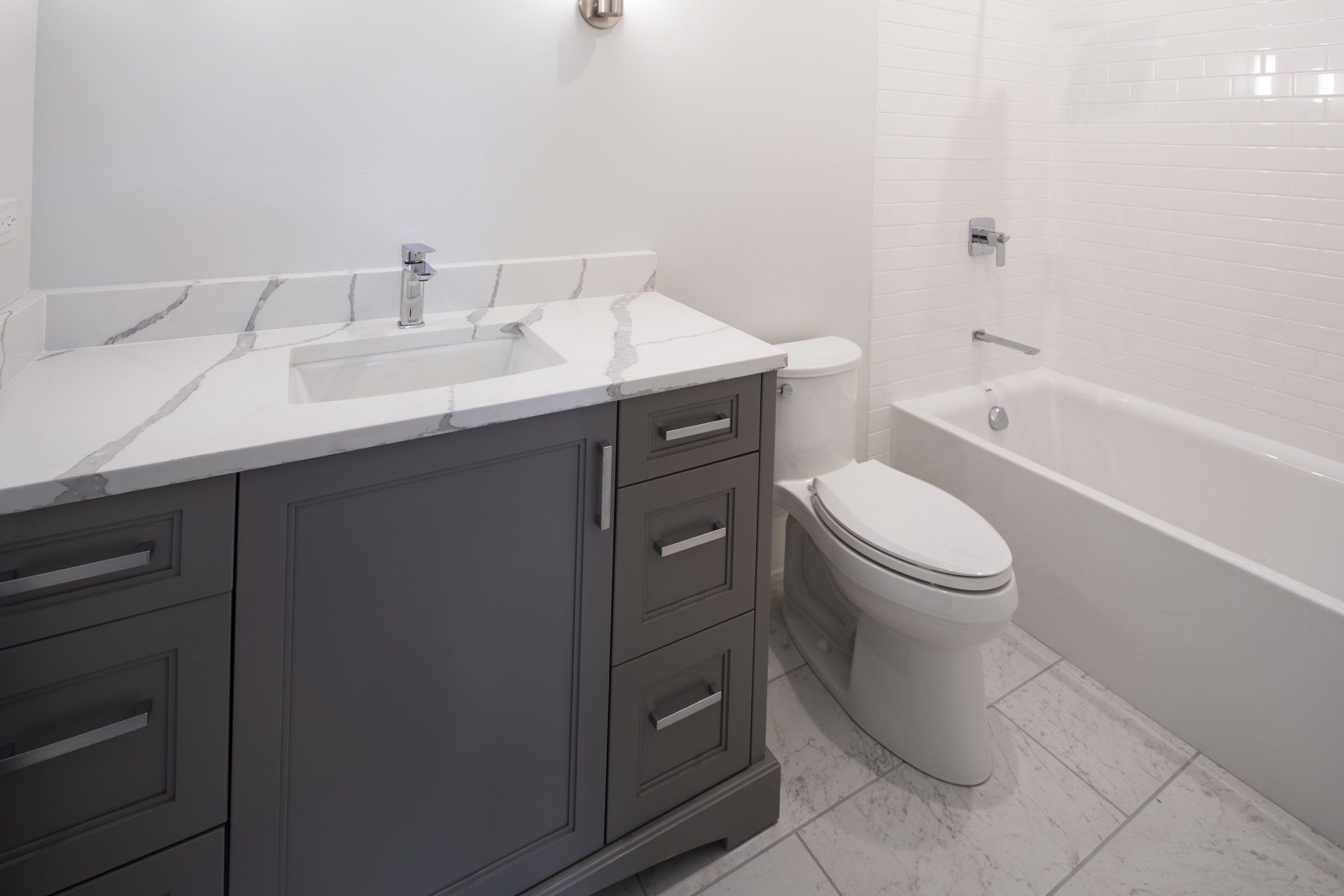 A bathroom with a toilet , sink , and bathtub.