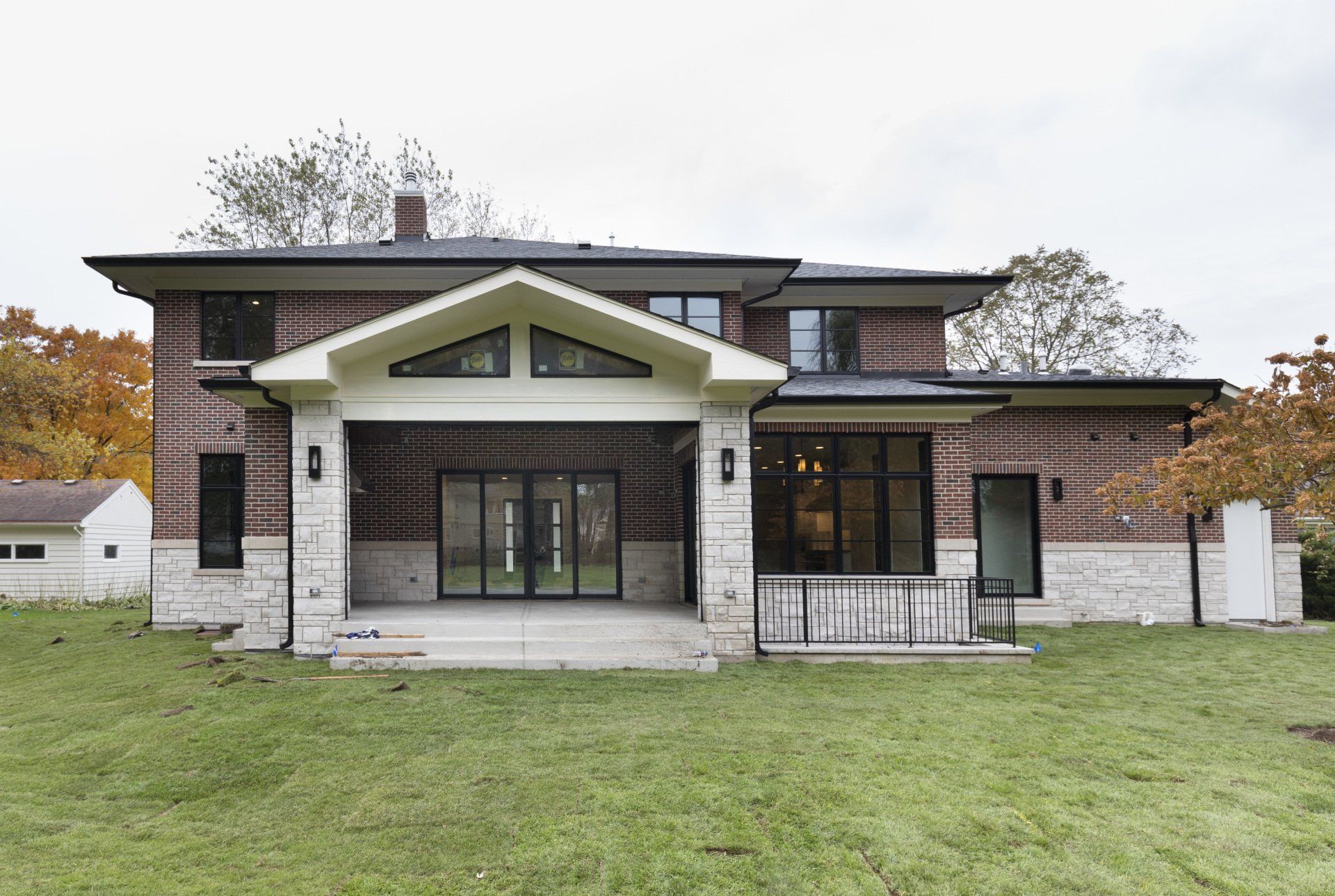 A large brick house with a large lawn in front of it.