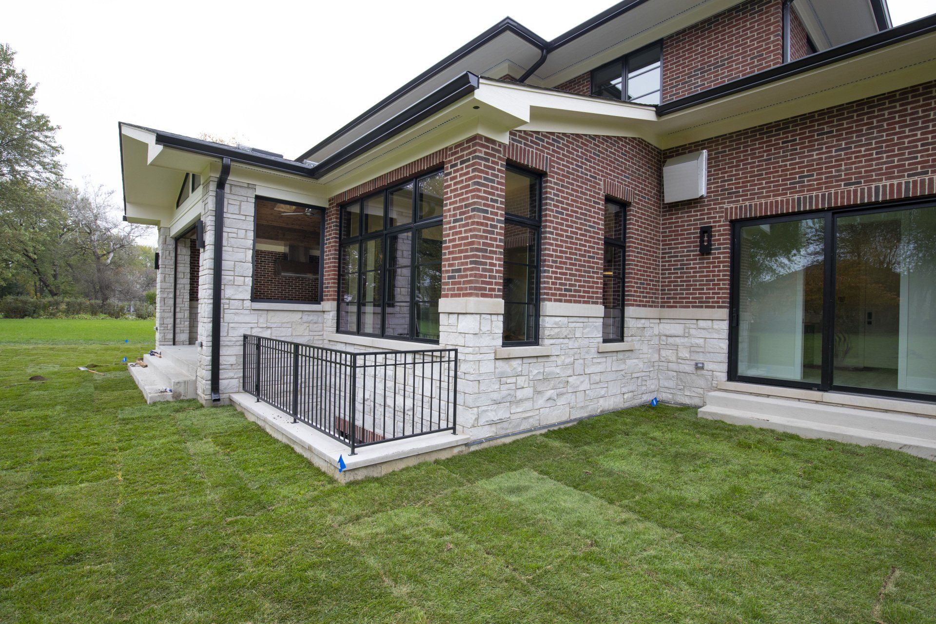 A large house with a lot of windows and a large lawn in front of it.