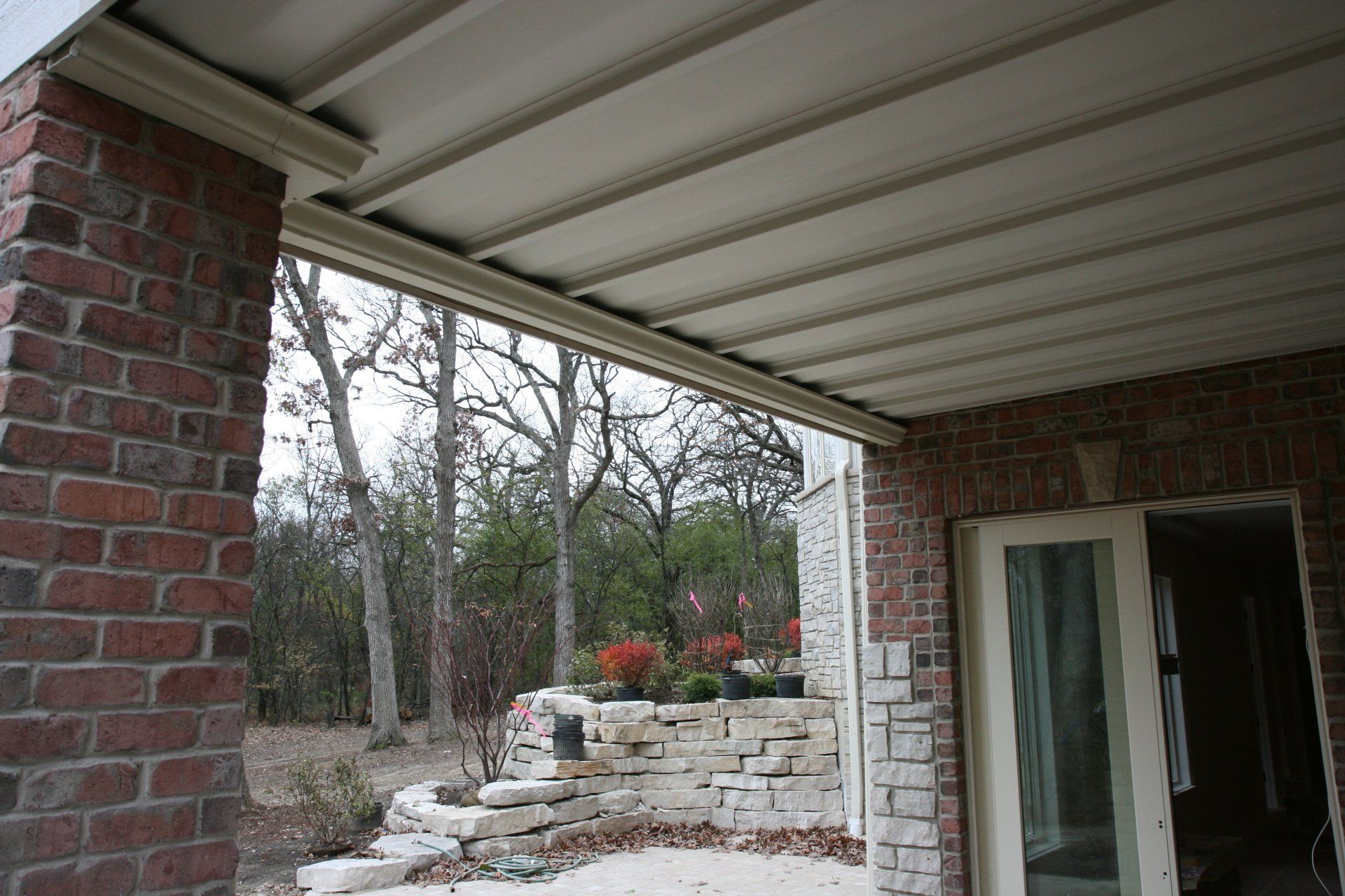 A porch with a brick wall and trees in the background