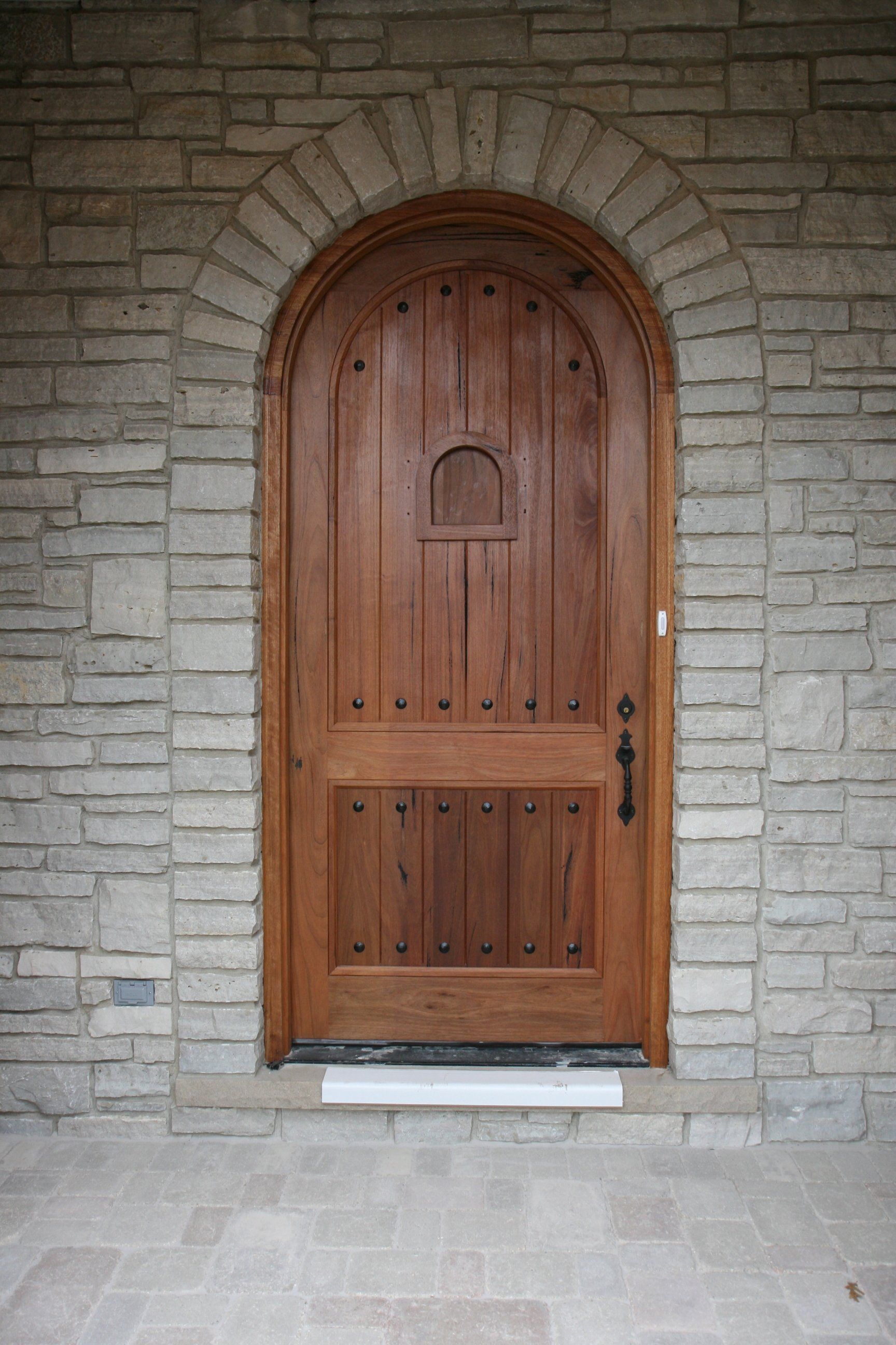 A wooden door with a stone wall behind it