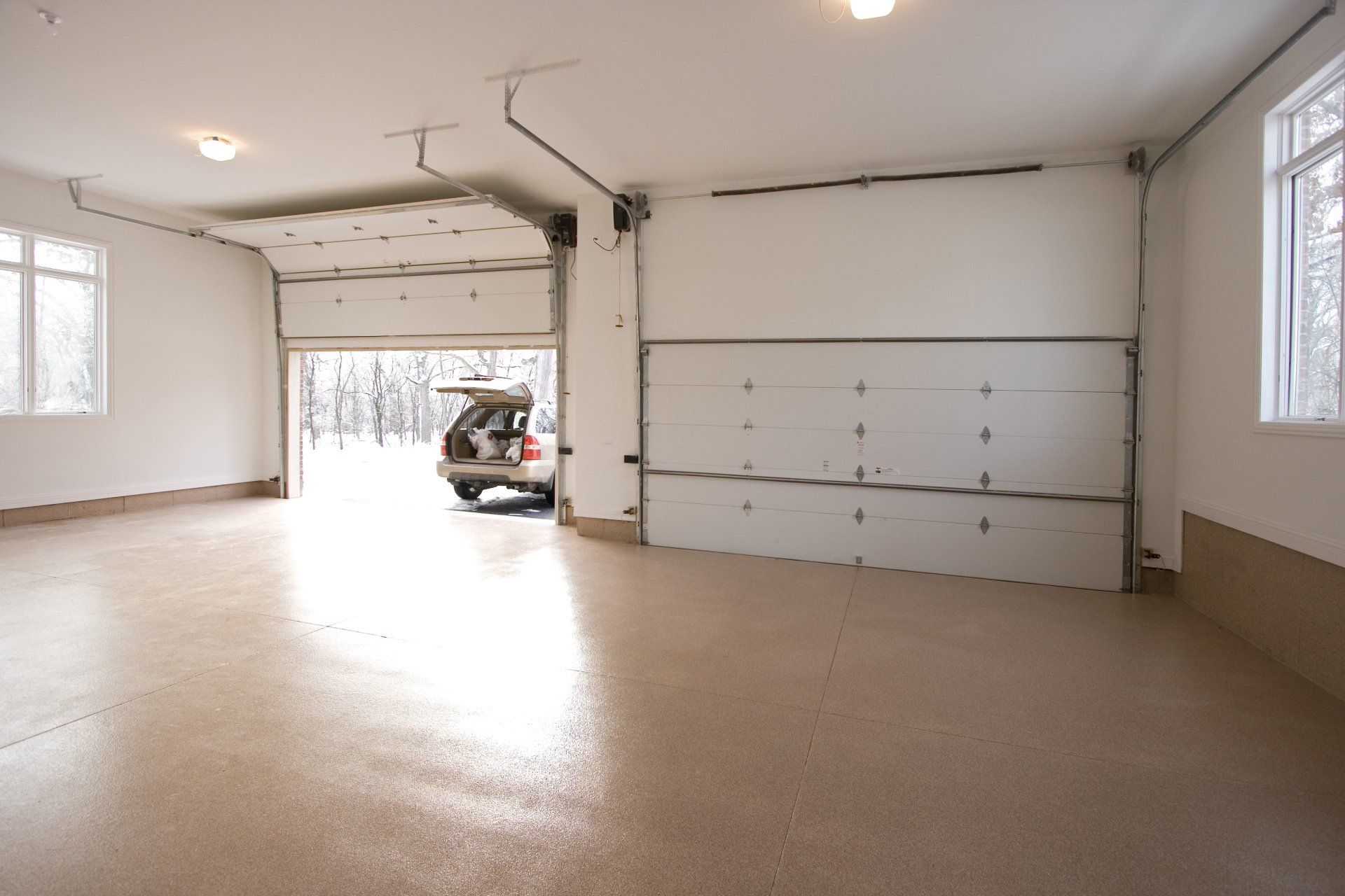 A car is parked in a garage with the door open