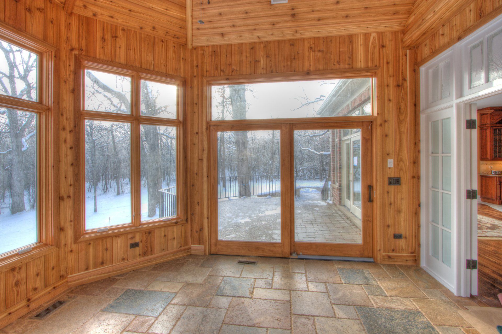 An empty room with a lot of windows and sliding glass doors.