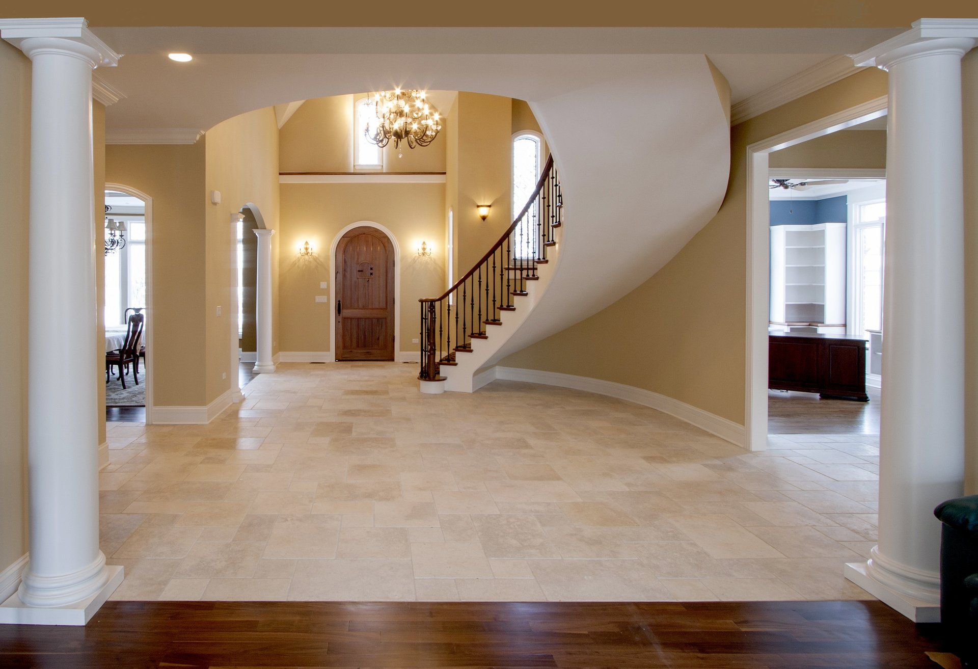 A large hallway with a spiral staircase and columns