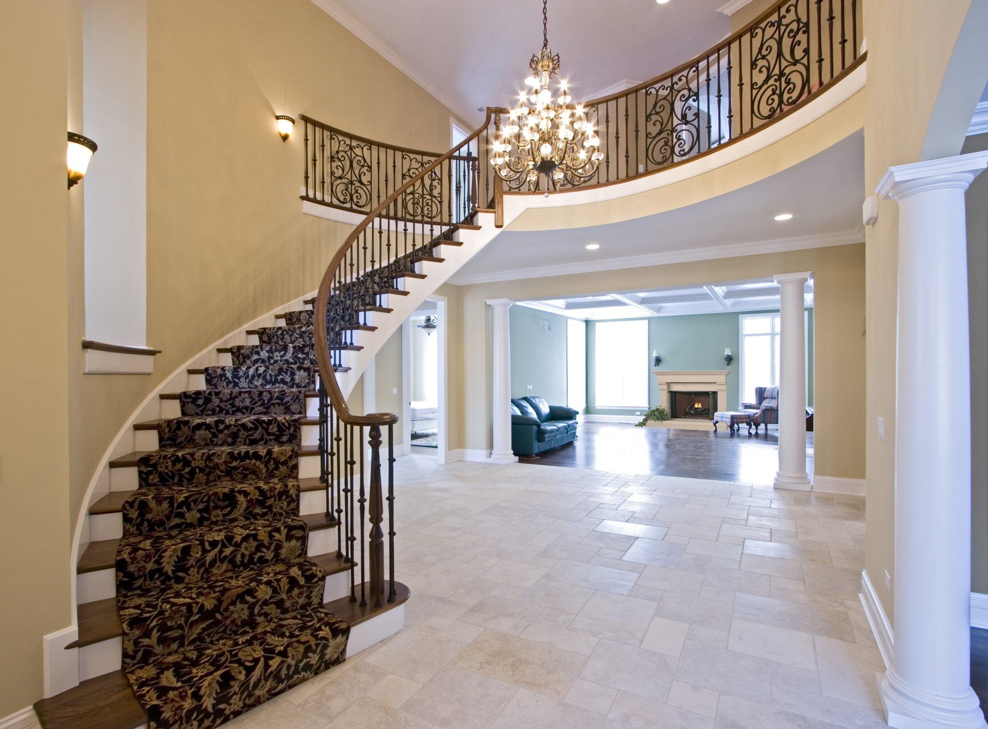 A large house with a curved staircase and a chandelier