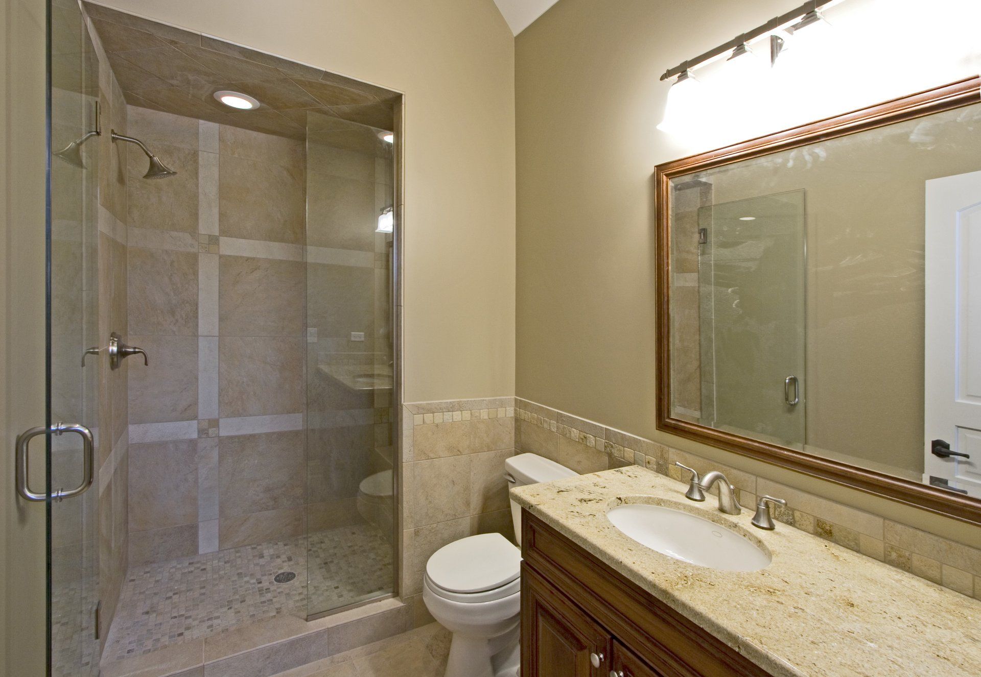 A bathroom with a toilet a sink and a walk in shower