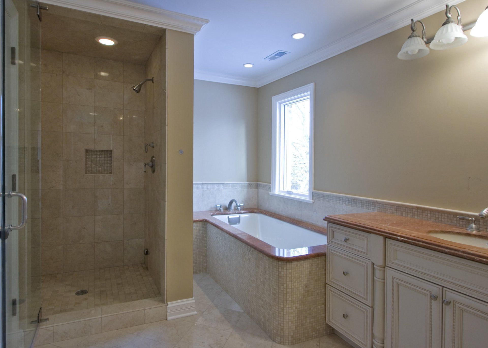 A bathroom with a tub and a walk in shower.
