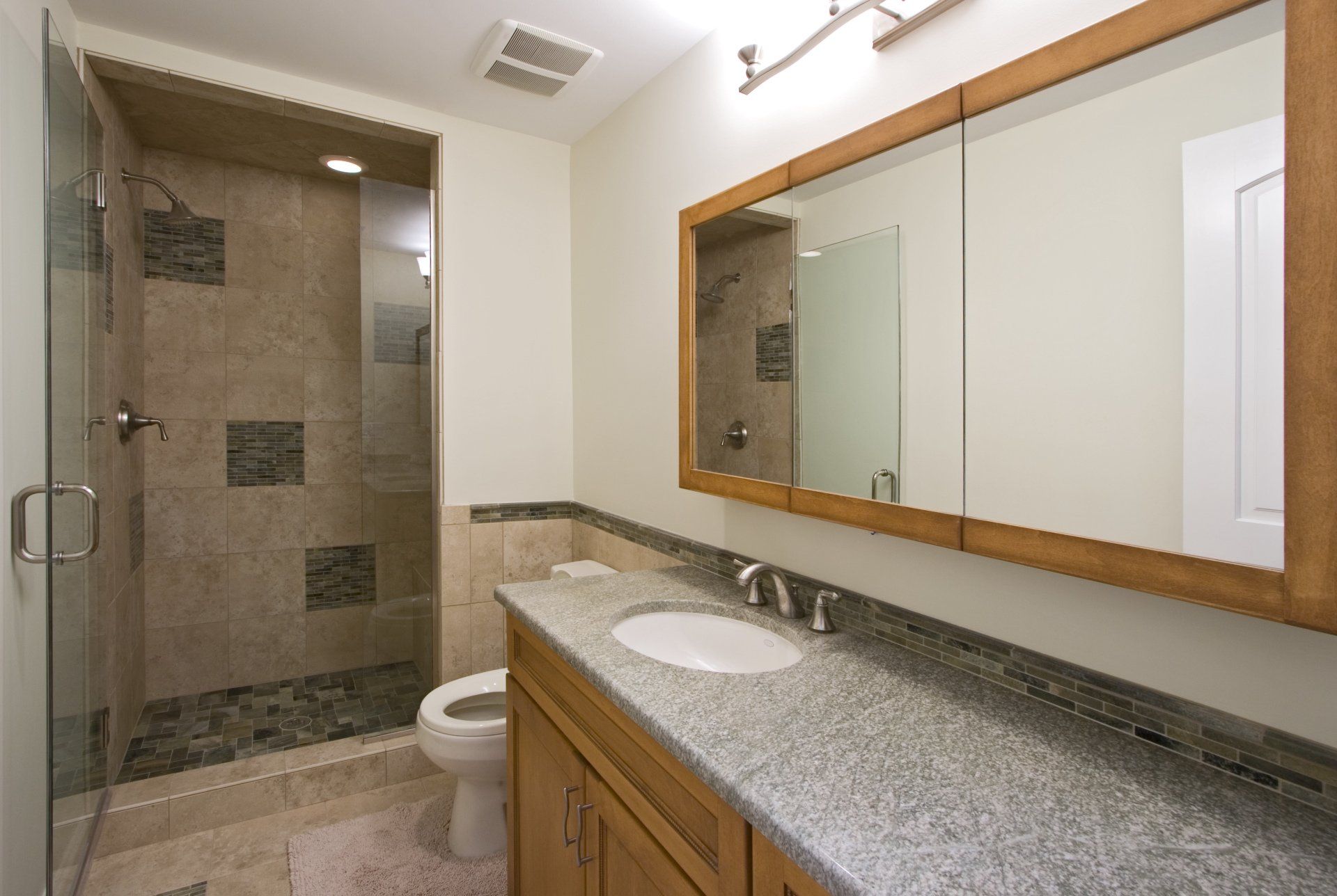 A bathroom with a toilet a sink and a mirror