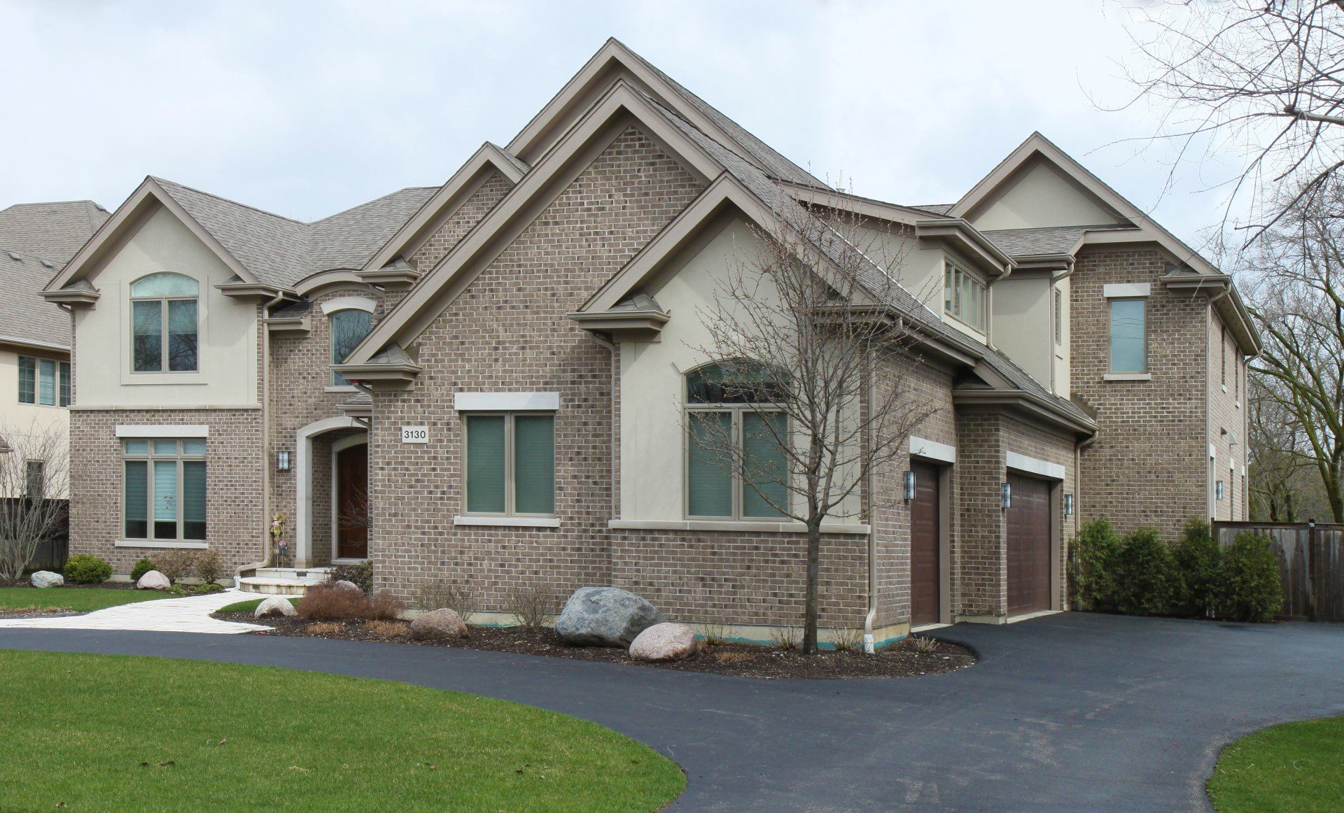 A large brick house with a driveway in front of it