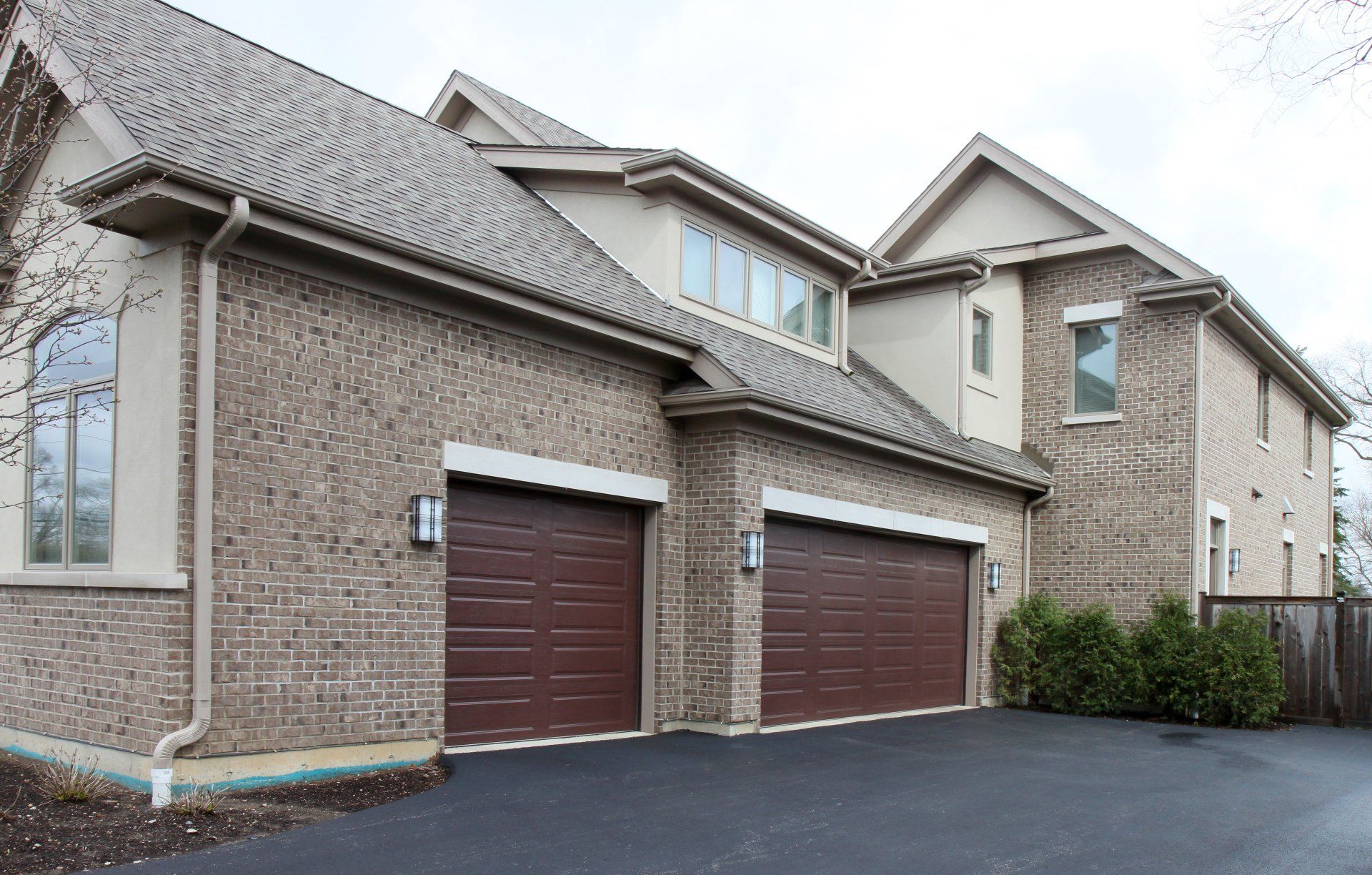 A large house with three garage doors and a driveway