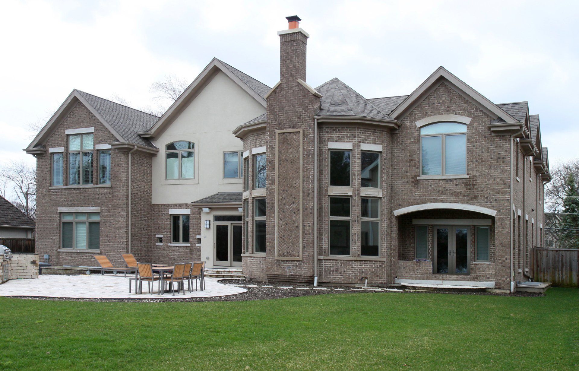 A large brick house with a large lawn in front of it