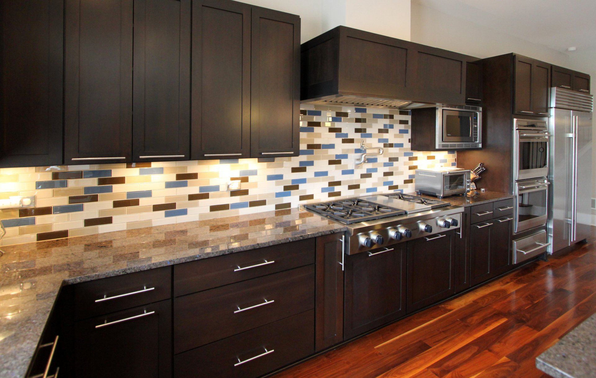 A kitchen with black cabinets and stainless steel appliances