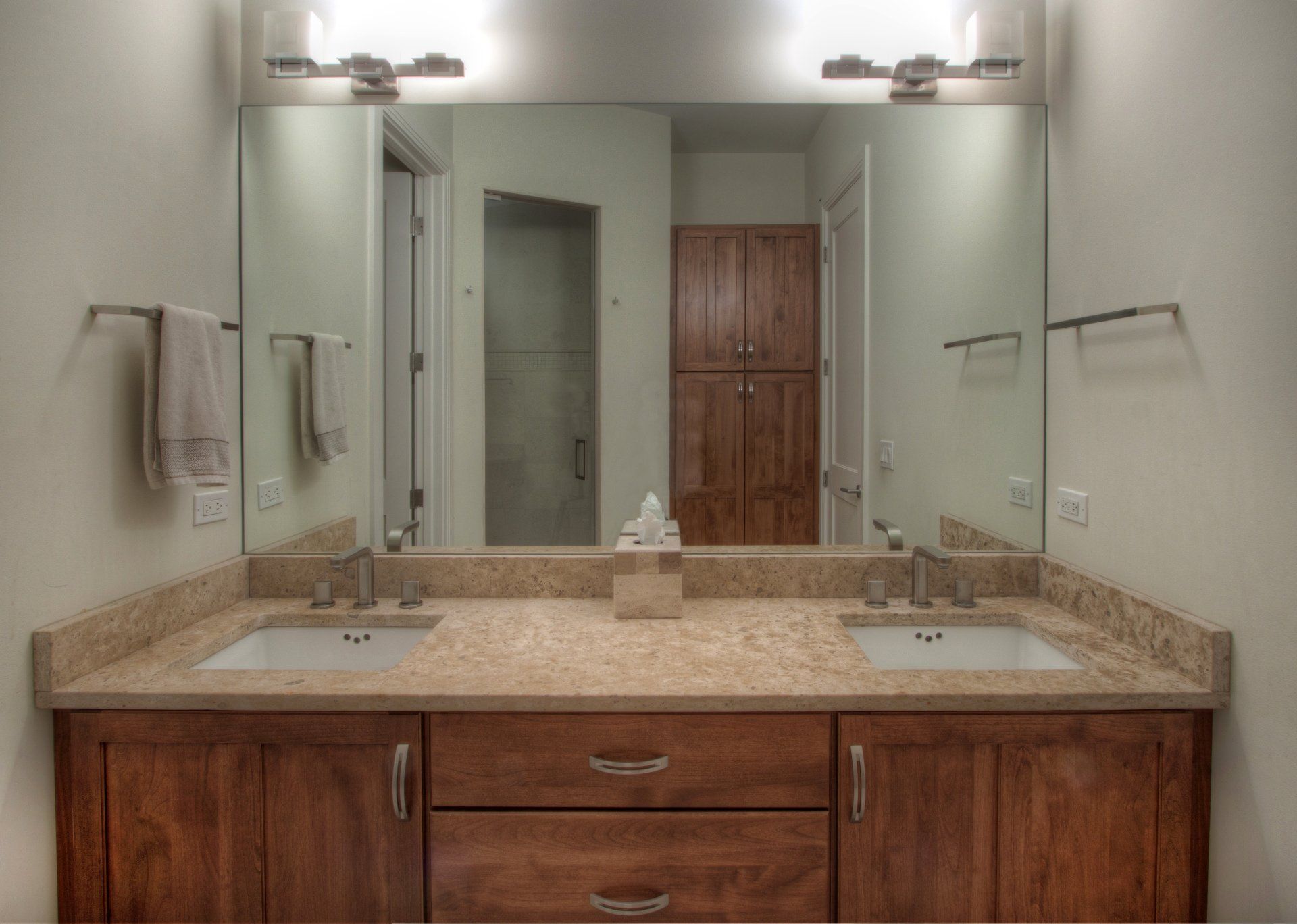 A bathroom with two sinks and a large mirror.