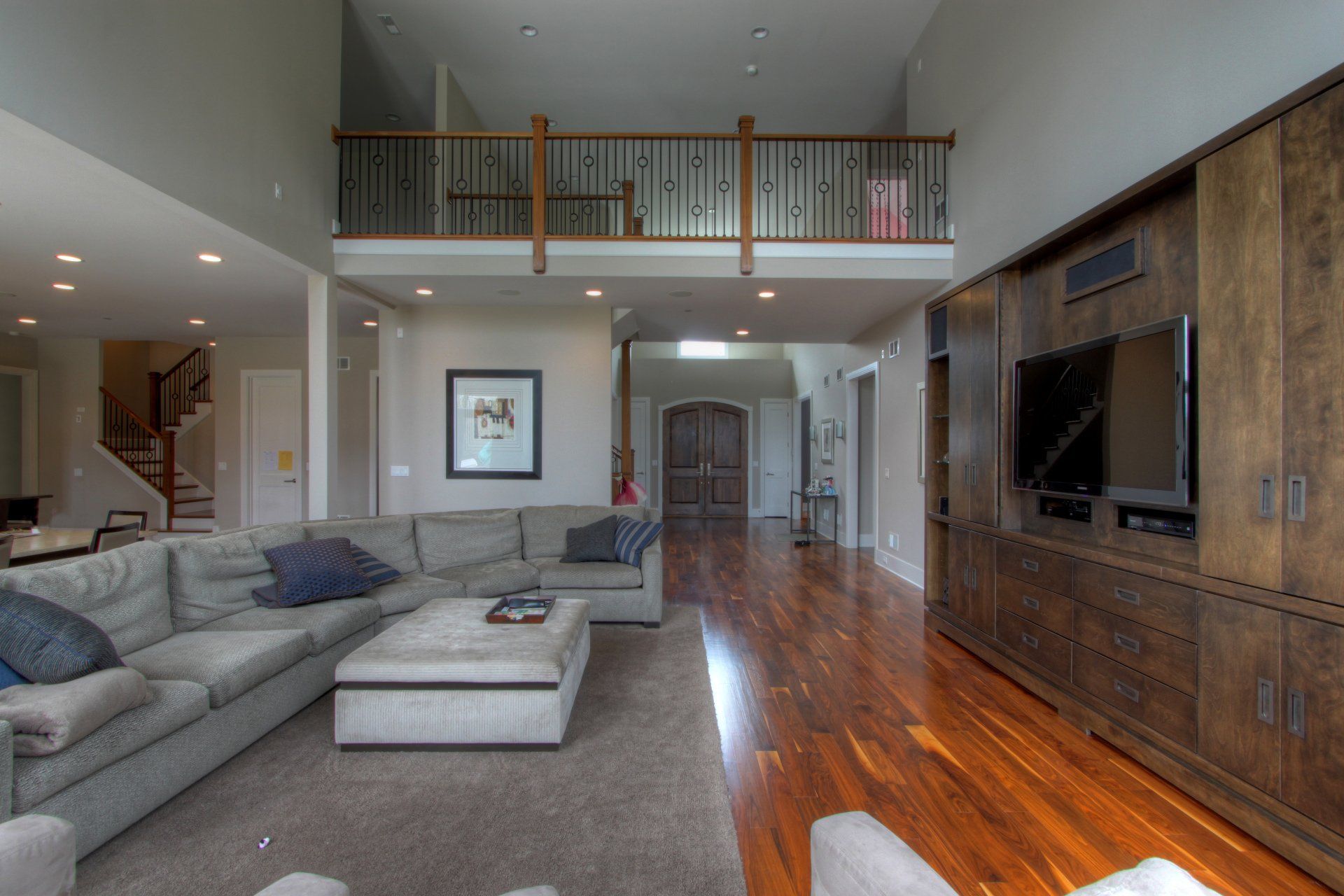 A living room with a large sectional couch and a flat screen tv.