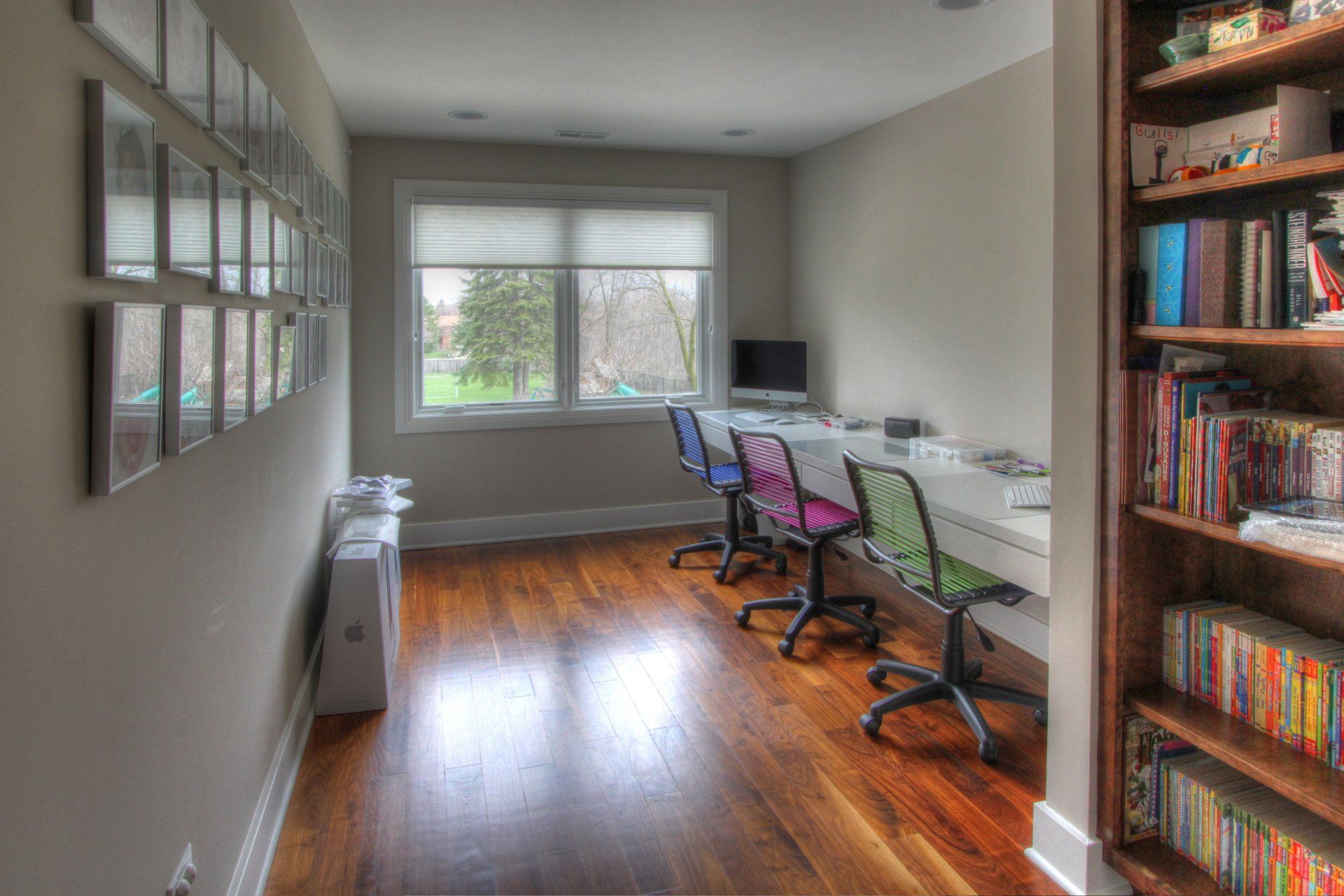 A room with a lot of bookshelves and desks and chairs.