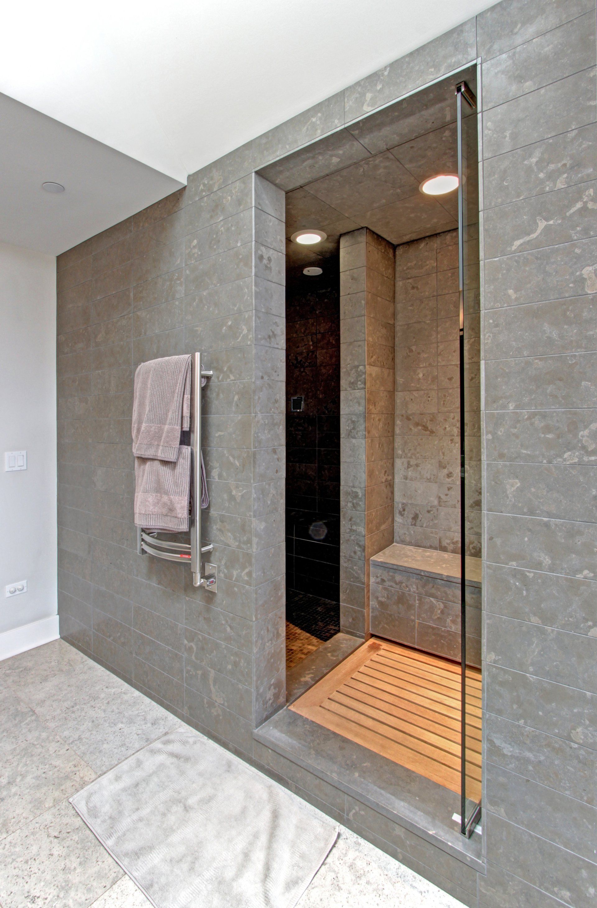 A bathroom with a walk in shower and a towel rack.