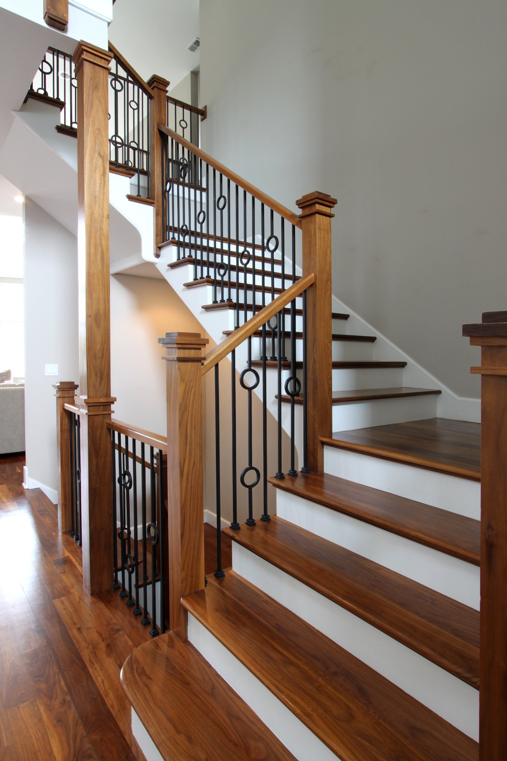 A wooden staircase with white steps and a black railing
