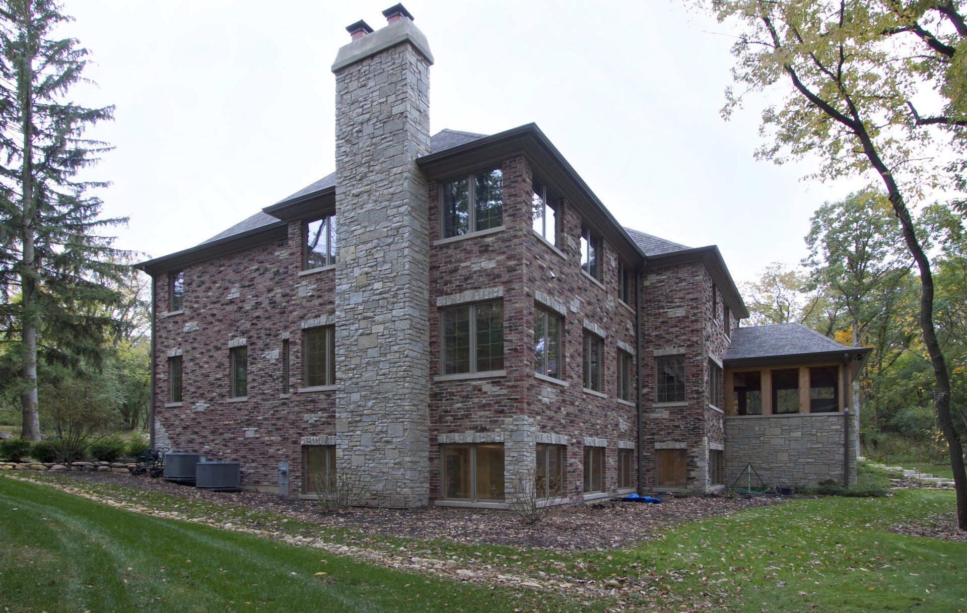 A large stone house with a chimney on top of it