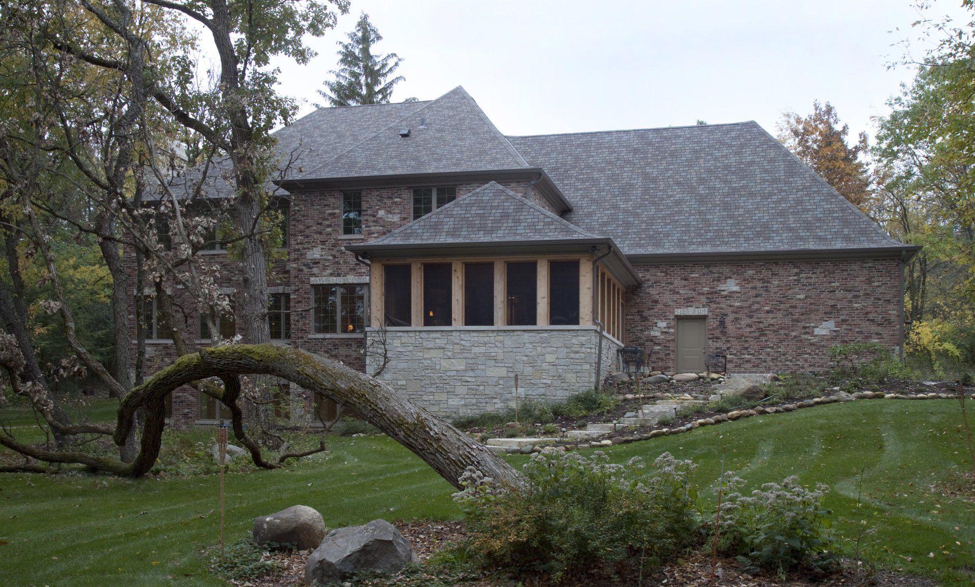 A large brick house with a tree in front of it