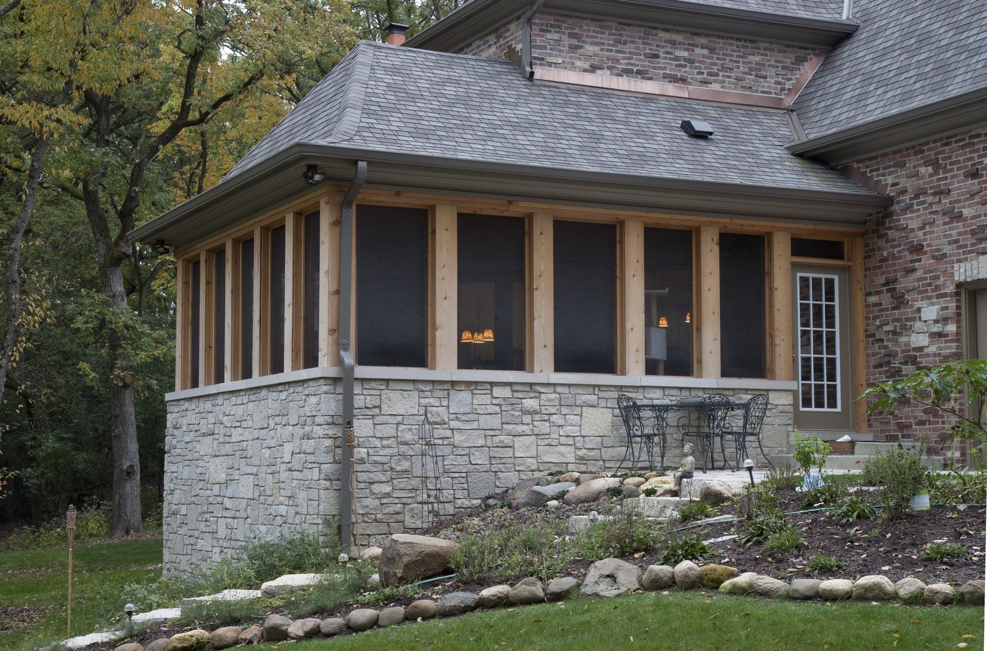A screened in porch on the side of a house