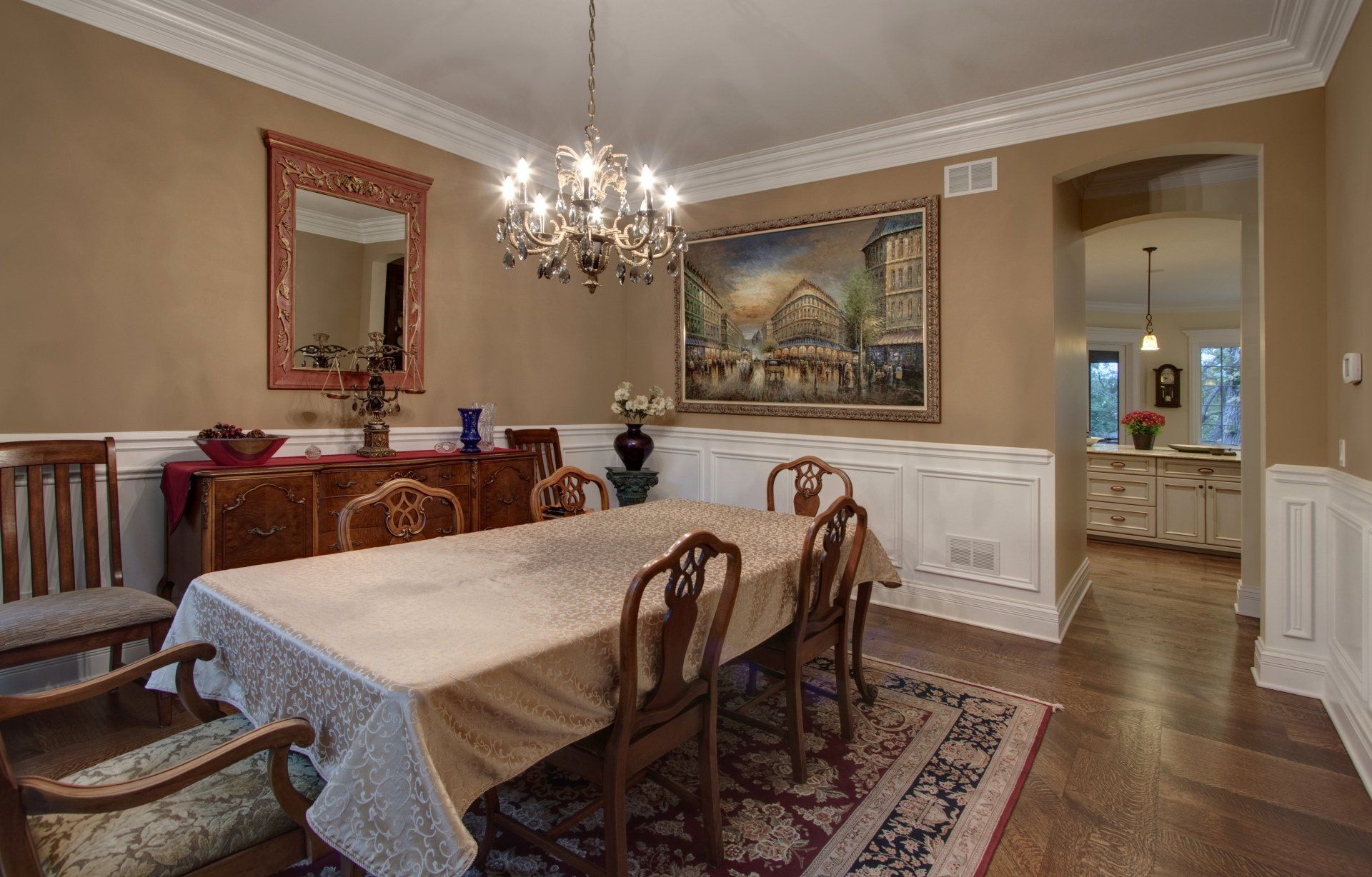 A dining room with a long table and chairs and a chandelier.