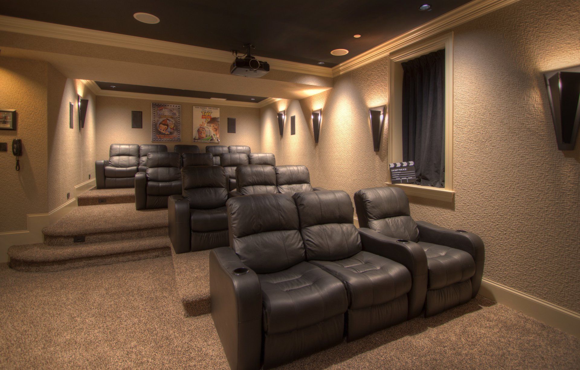 A home theater with leather couches and a projector.