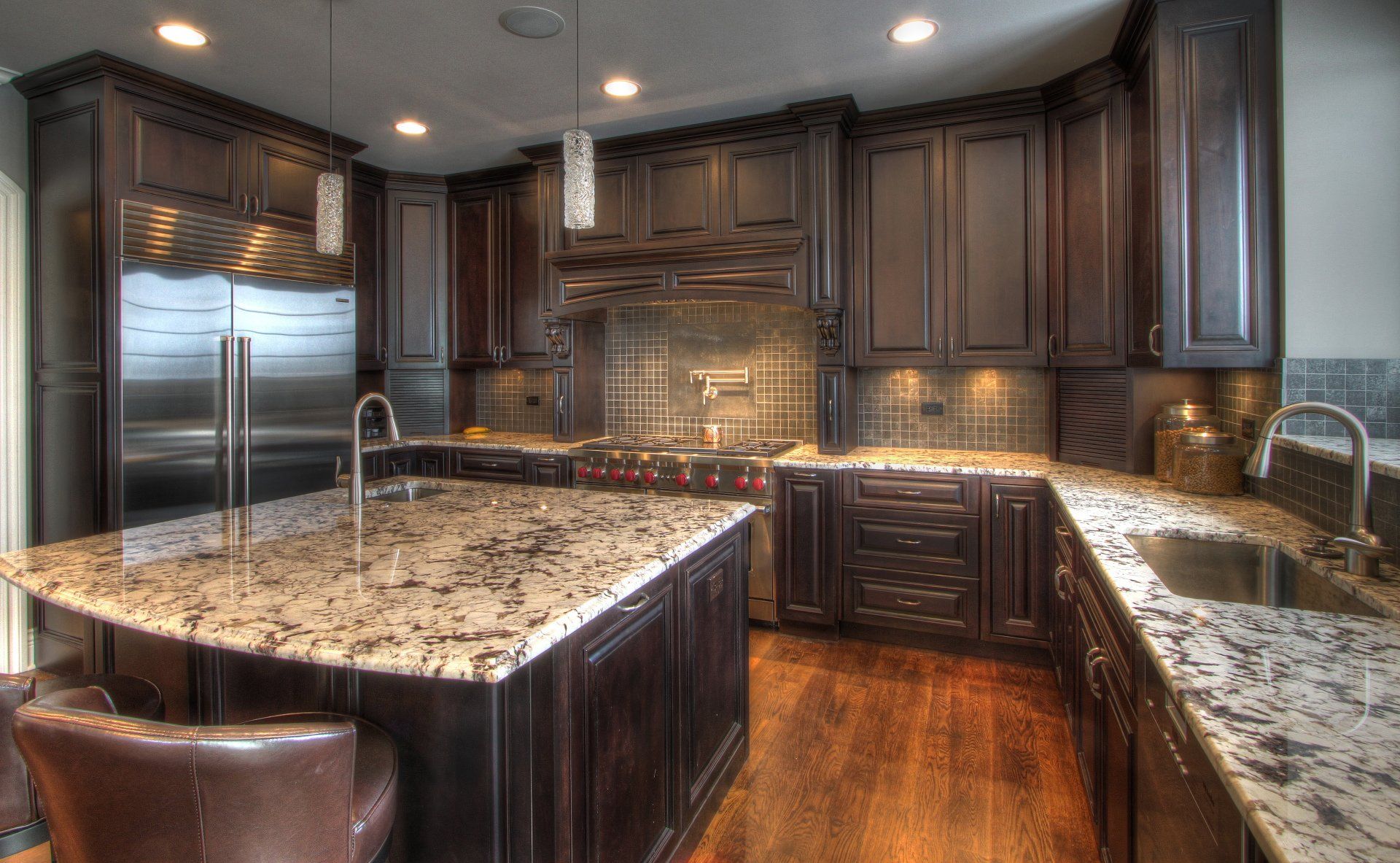 A kitchen with a large island and granite counter tops.