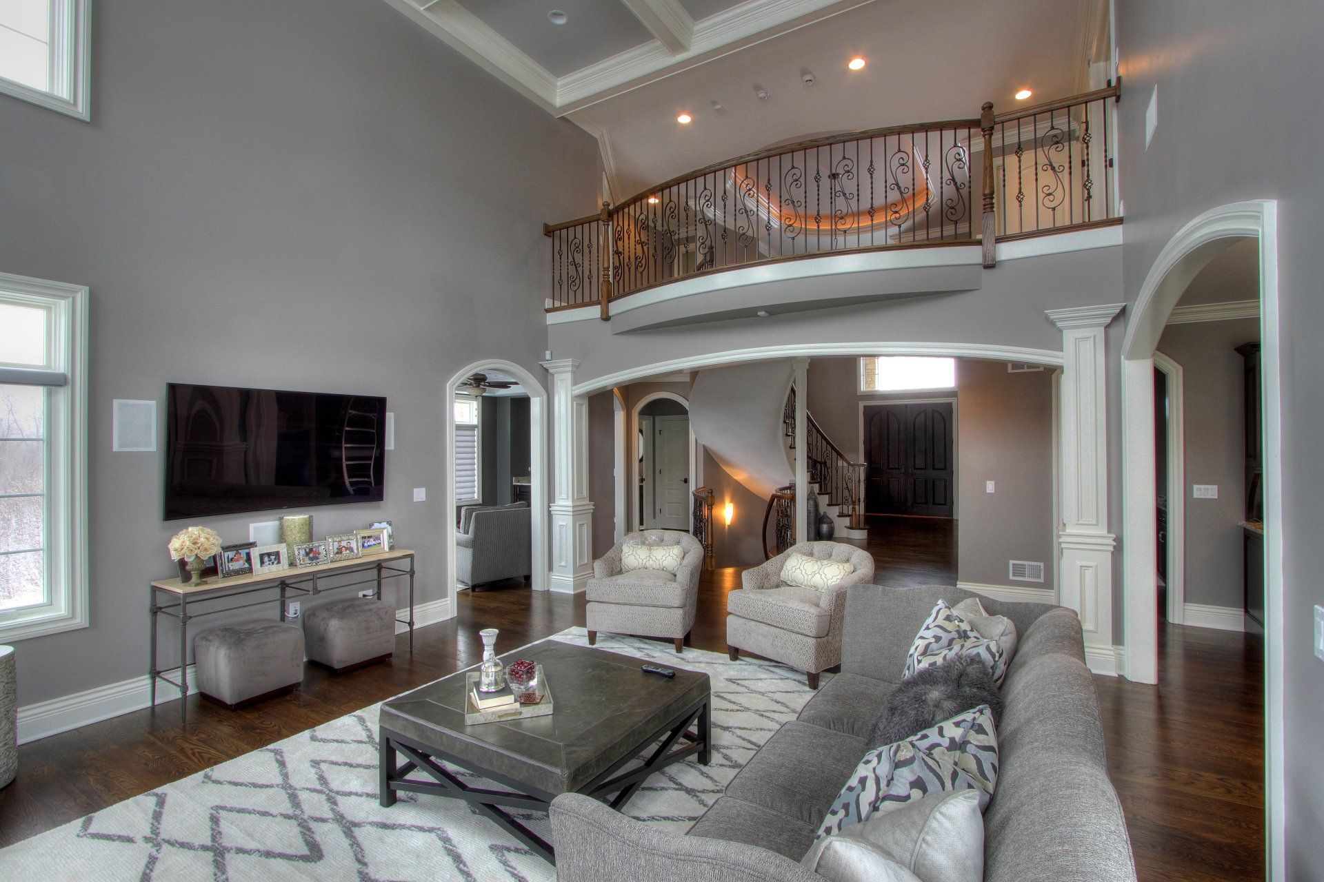 A living room with a couch , chairs , coffee table and television.