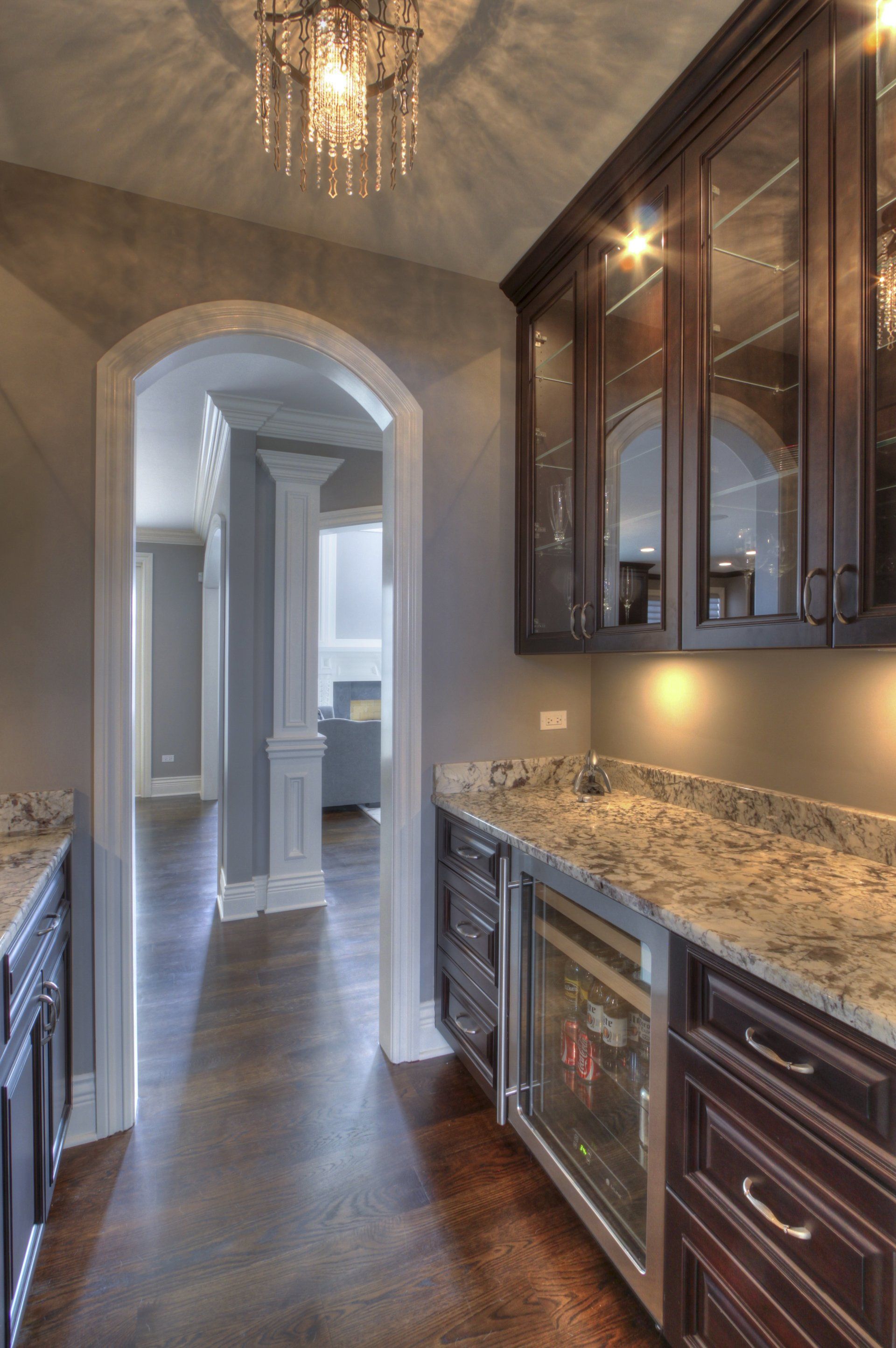 A kitchen with marble counter tops and a wine cooler