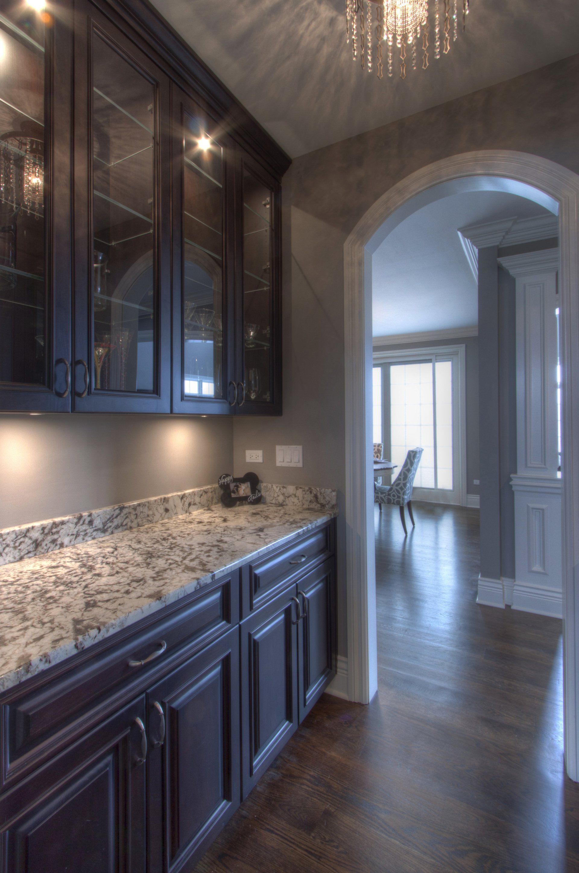 A kitchen with dark cabinets and granite counter tops