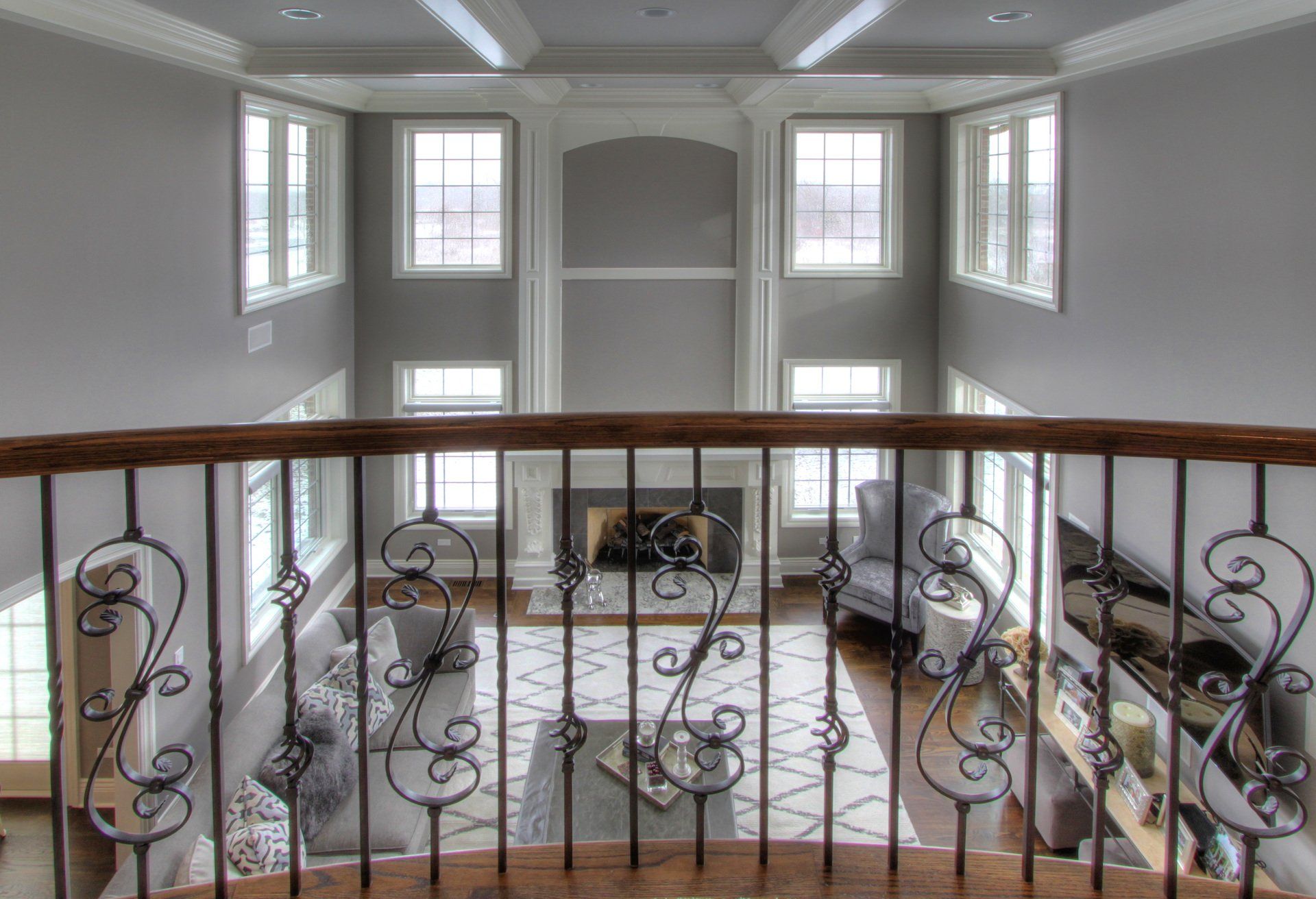 A view of a living room from a balcony with a wrought iron railing.