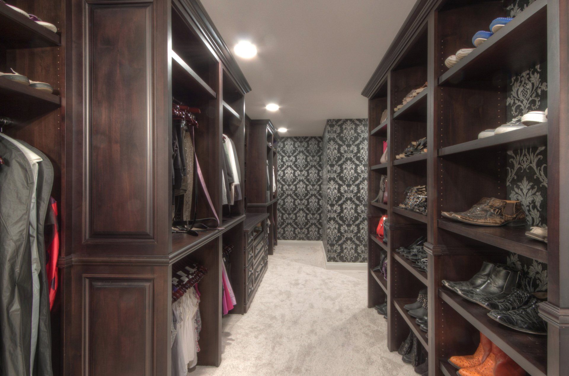 A walk in closet filled with clothes and shoes