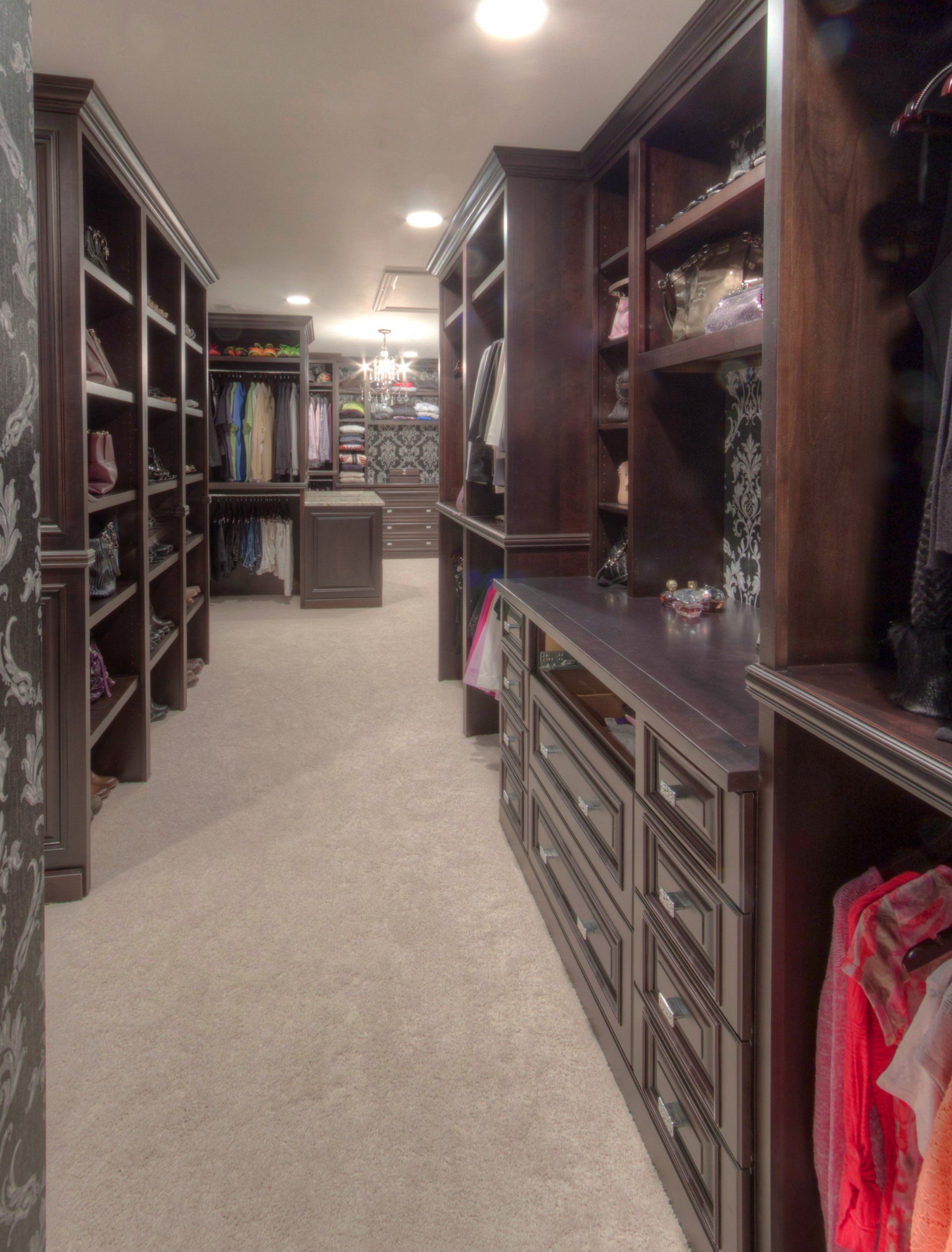 A walk in closet with lots of shelves and drawers