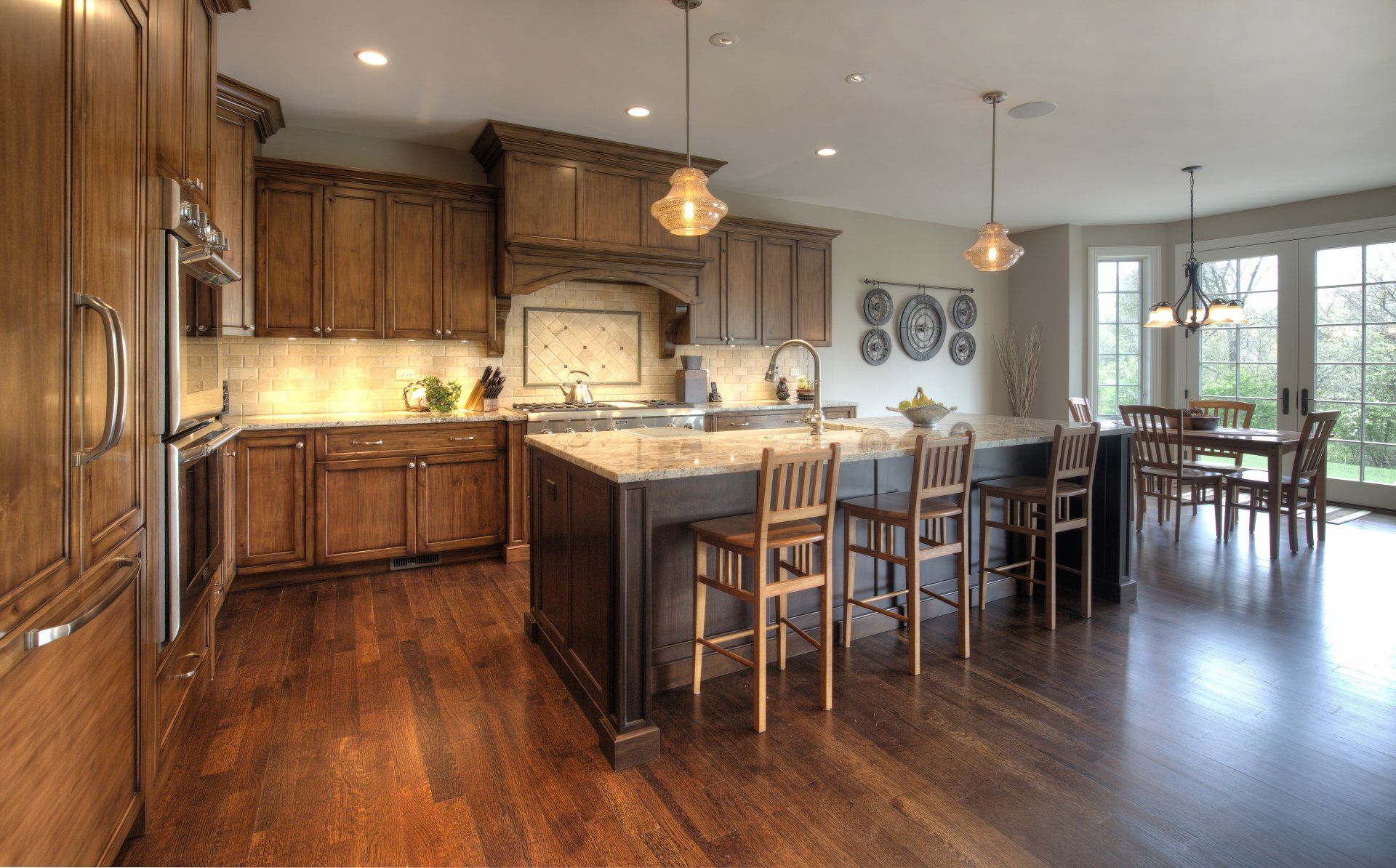 A kitchen with wooden cabinets , granite counter tops , stainless steel appliances and a large island.