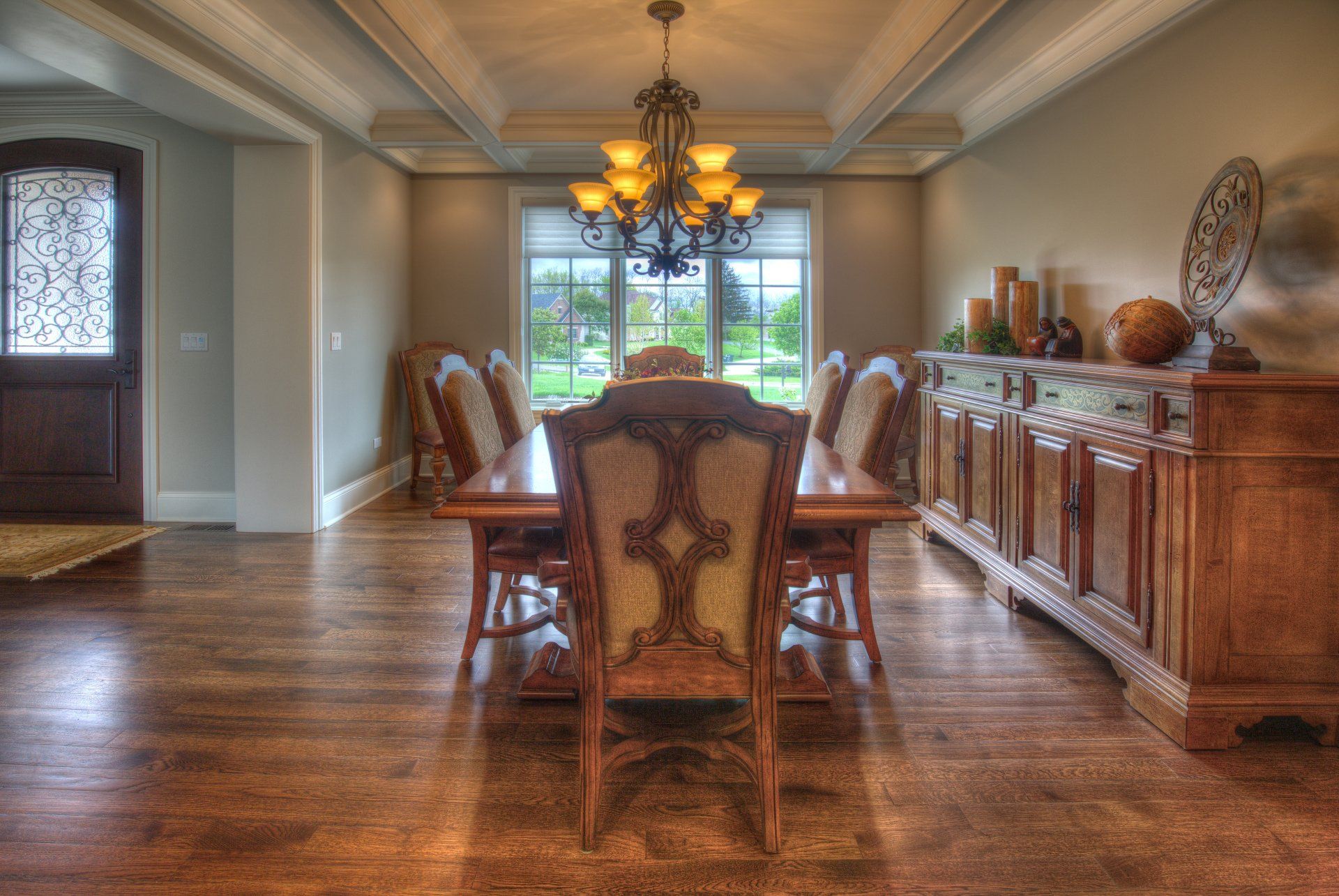 A dining room with a long table and chairs and a chandelier.