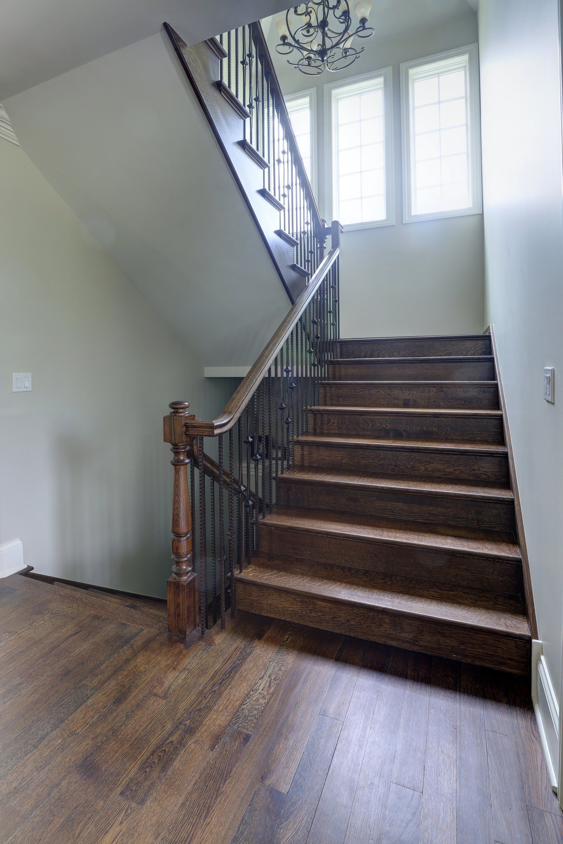 A wooden staircase with a metal railing in a house.